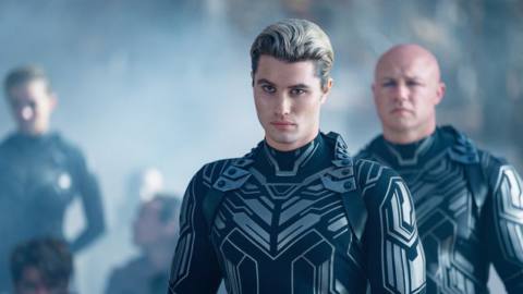 Peris (Chase Stokes), a man with dark roots and frosted hair, wearing a futuristic full-body armored suit covered with circuitry-like patterns, stands in a group of similarly dressed men in Netflix’s Scott Westerberg adaptation Uglies