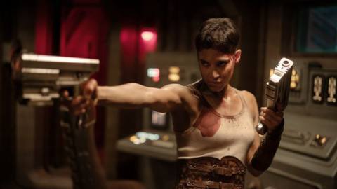 Sofia Boutella as Kora holding up guns