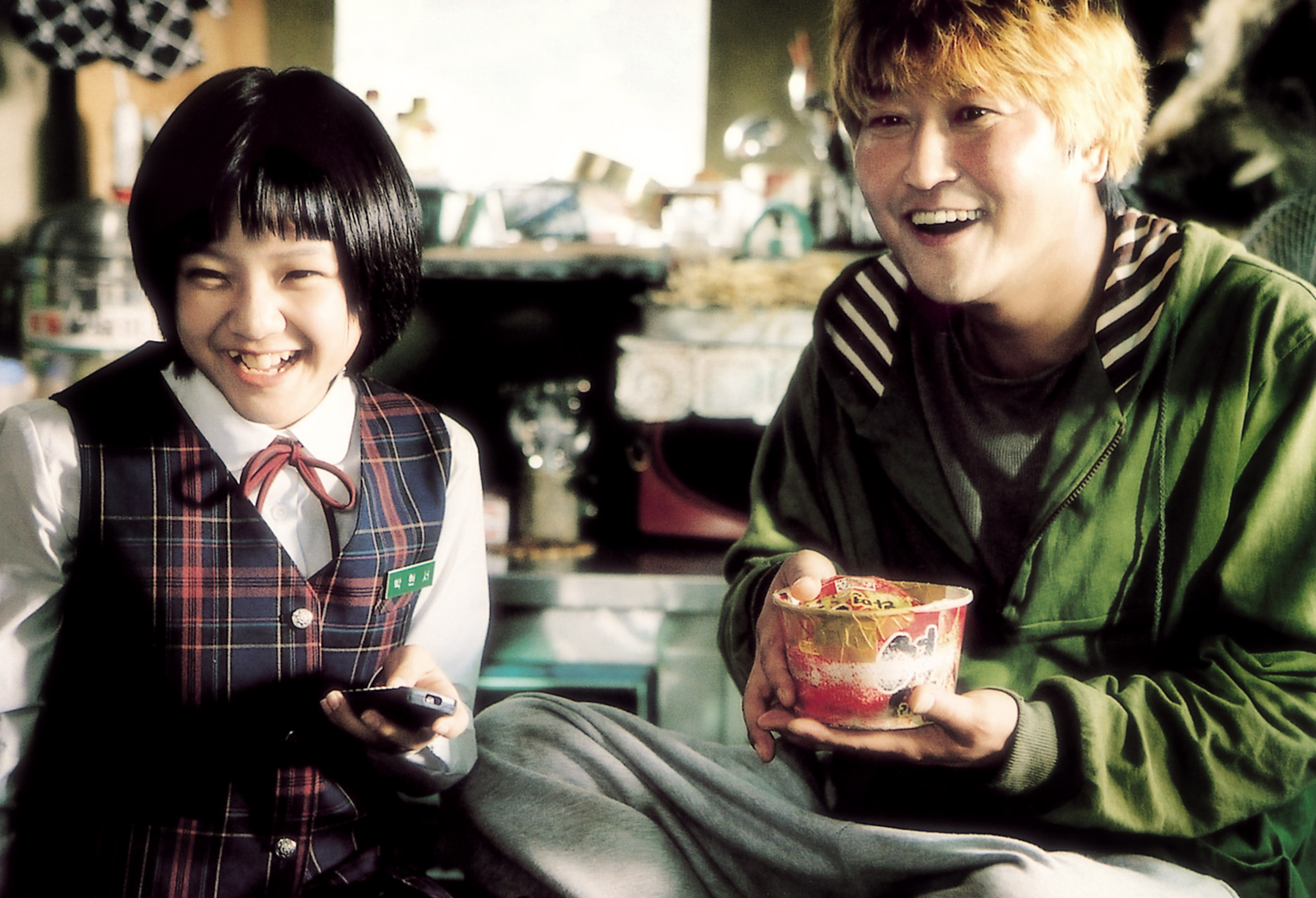 Ko Ah-sung sits next to Song Kang-ho, who is eating instant ramen in The HostKo Ah-sung sits next to Song Kang-ho, who is eating instant ramen in The Host