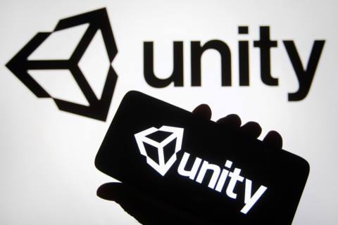 In this photo illustration, the Unity Technologies (Unity Software Inc.) logo is seen on a smartphone and a PC screen.