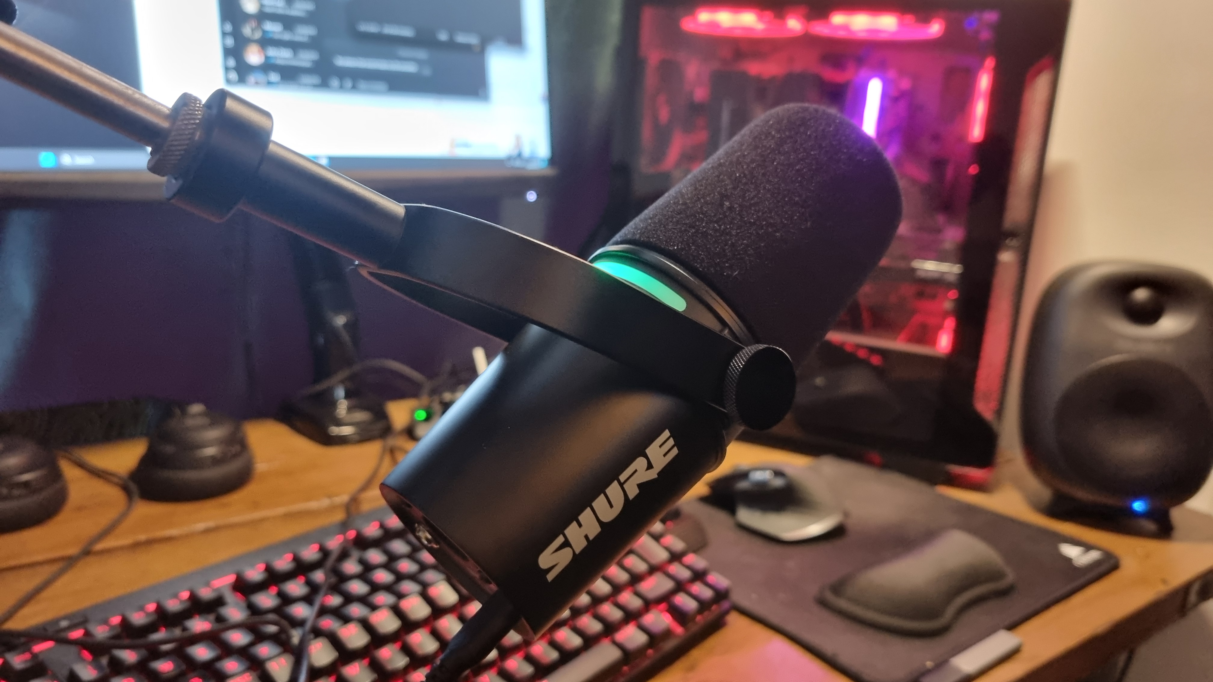 The Shure MV7 Plus Podcast Microphone mounted to a boom arm