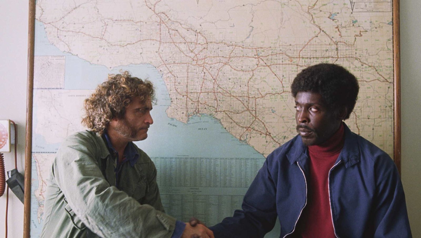 Joaquin Phoenix and Michael K. Williams
shaking hands in front of a map of Los Angeles in Inherent Vice.