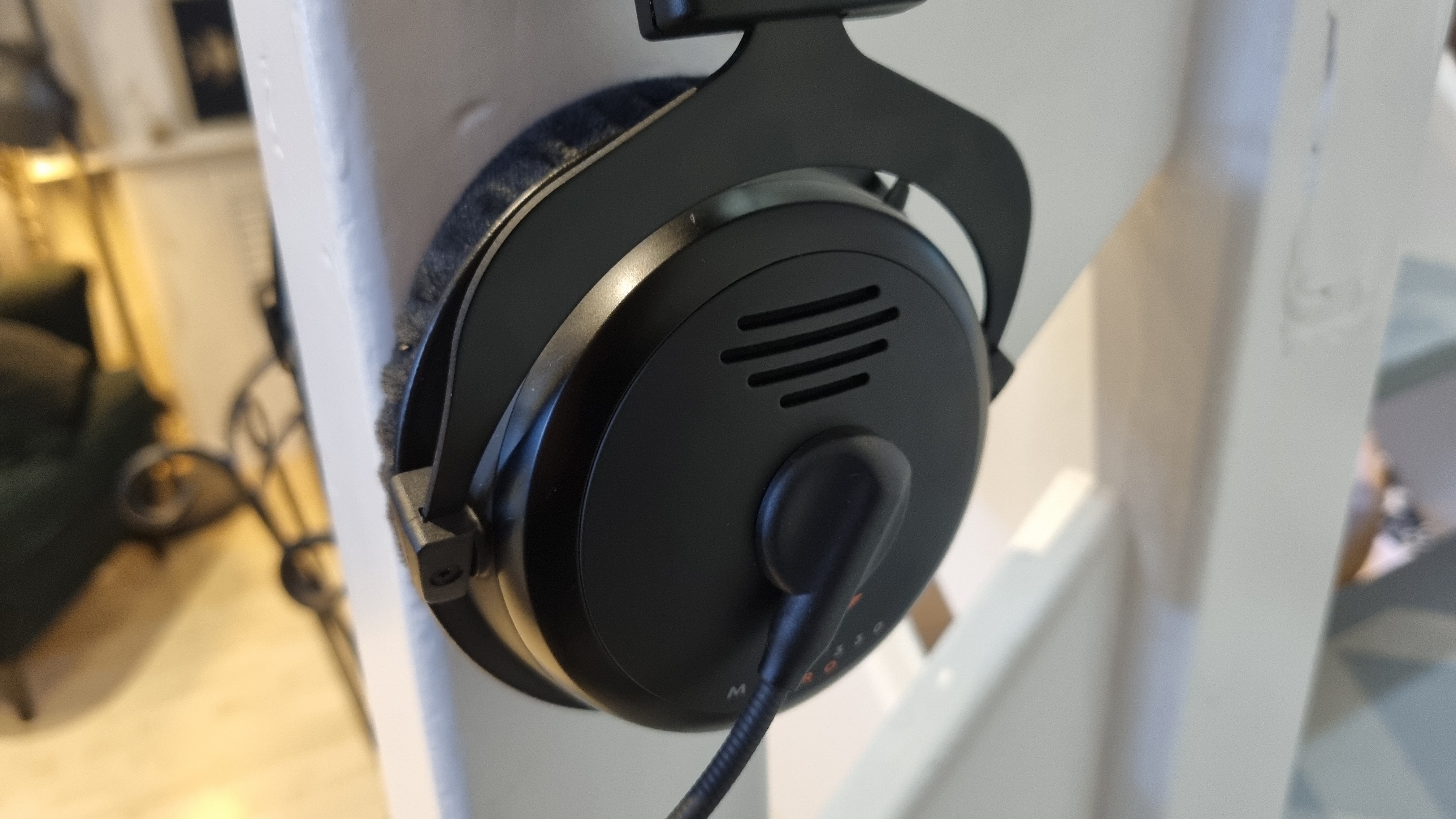 The left earcup of the Beyerdynamic MMX 300 Pro open-back gaming headset, showing the venting and the flip-down microphone attachment point.