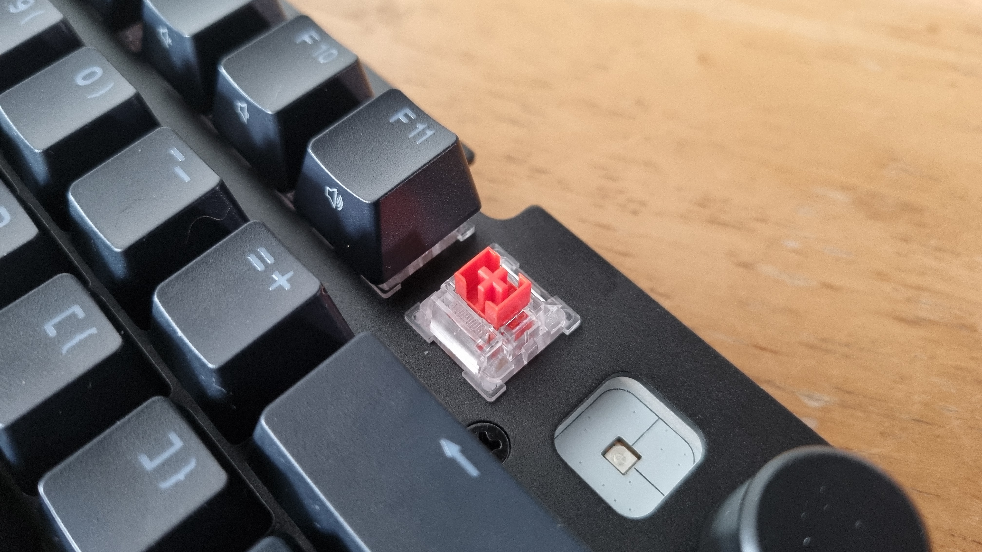 A keycap removed on the Glorious GMMK 3 HE, showing the red Fox Hall effect switches.