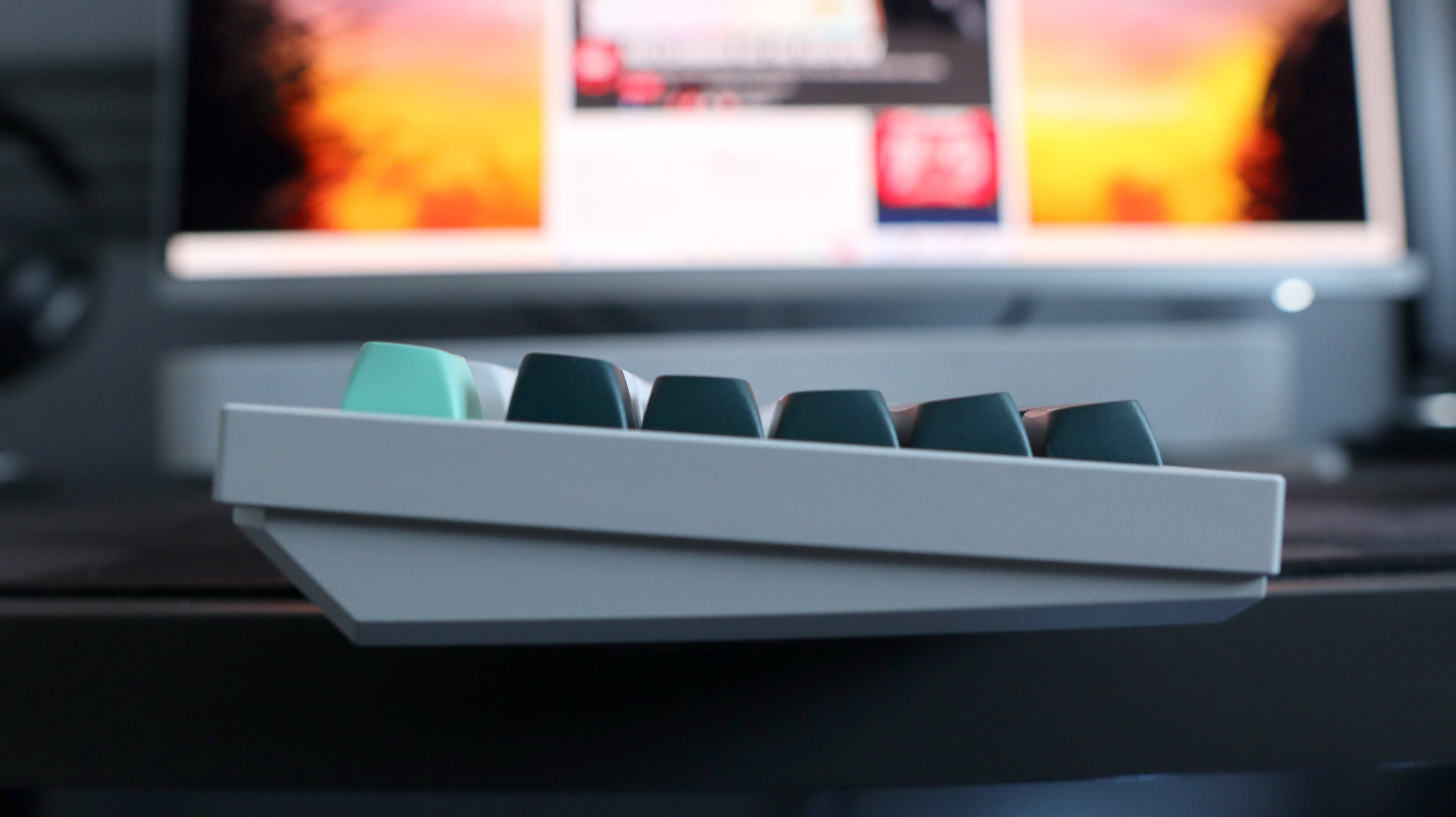 A Keychron Q5 HE gaming keyboard on a desk with white and blue keycaps.