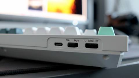 A Keychron Q5 HE gaming keyboard on a desk with white and blue keycaps.