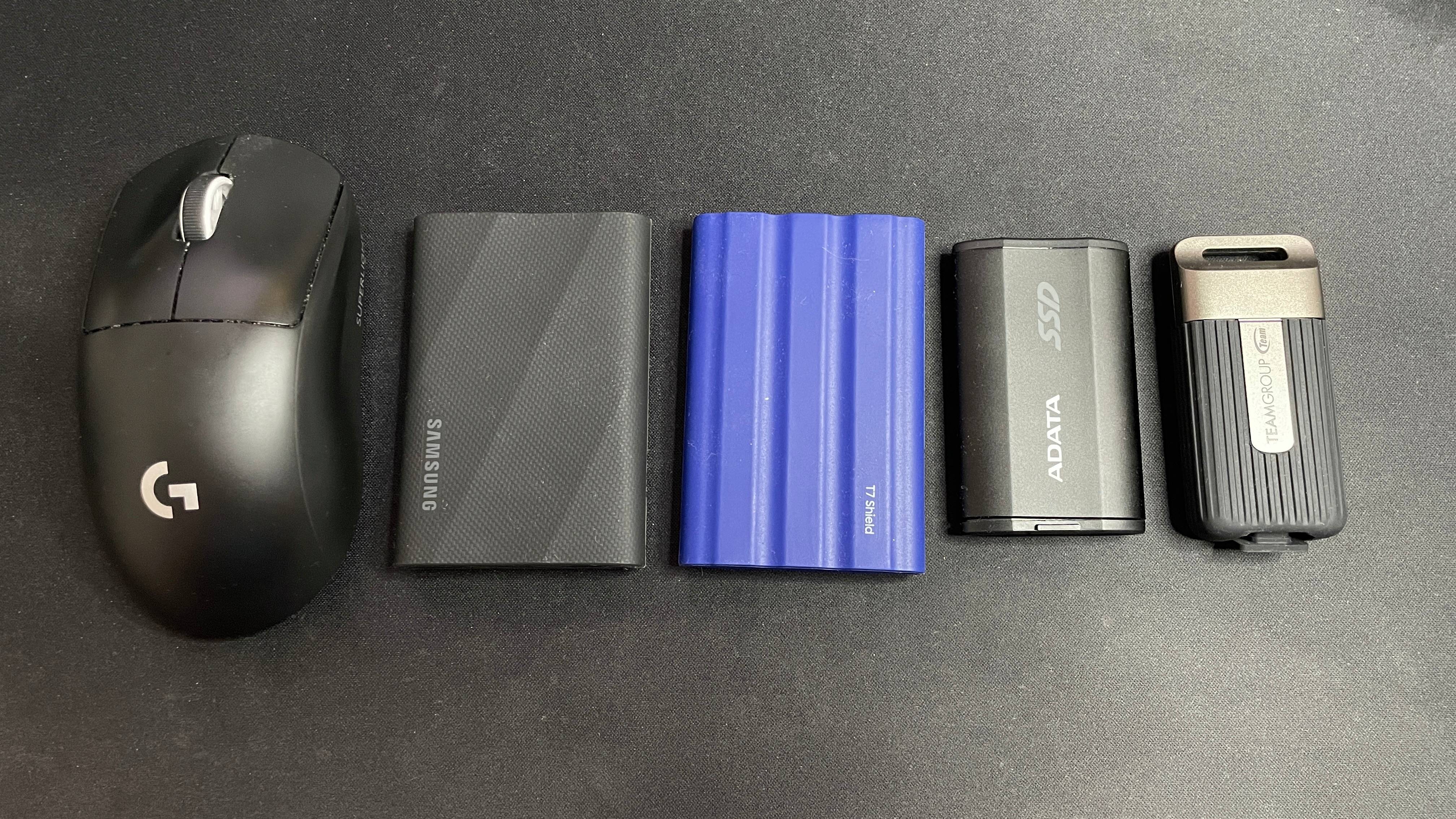 Samsung T9 SSD next to other SSDs and a mouse