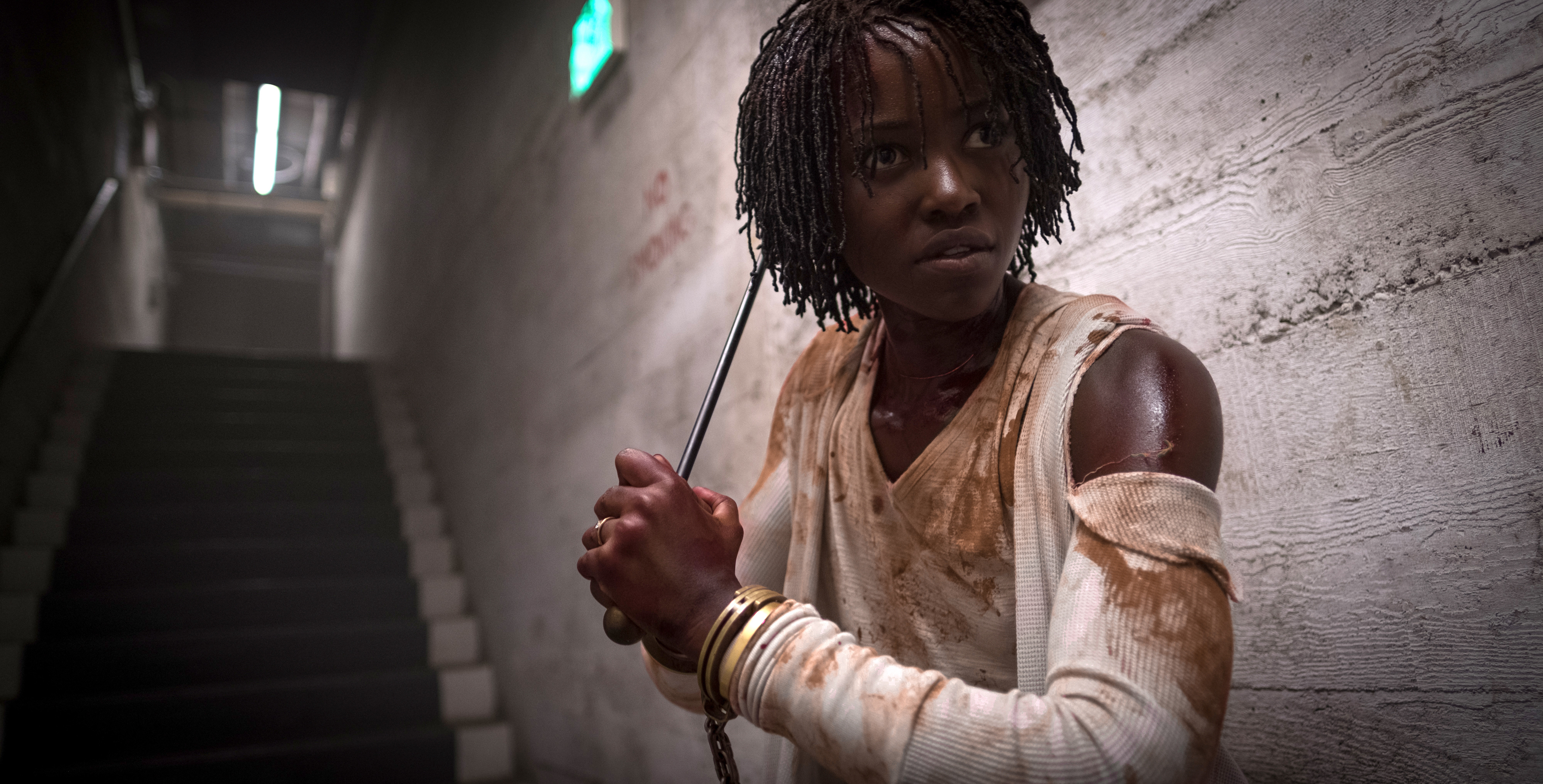 Lupita Nyong’o holding a golf club in Jordan Peele’s Us