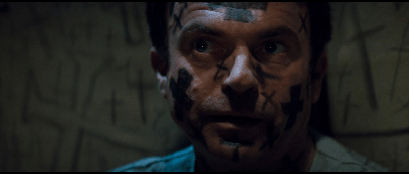 Sam Neill is having a very bad time in In the Mouth of Madness, with crosses sharpied on his face.