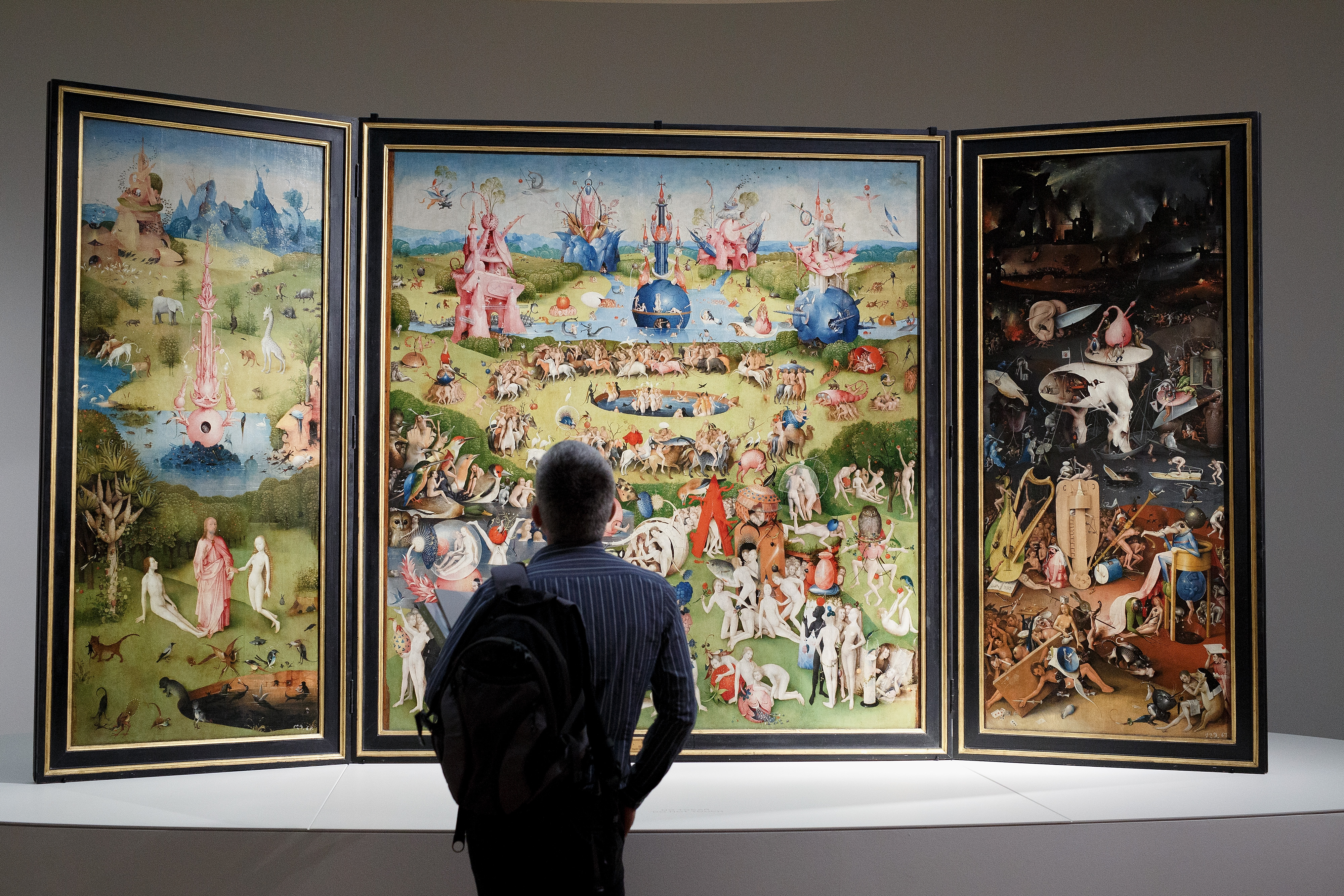 MADRID, SPAIN - MAY 27: A man looks at of 'The Garden of Earthly Delights Triptych' by the Dutch painter Hieronymus Bosch during a press preview of the 'El Bosco' 5th Centenary Anniversary Exhibition at El Prado Museum on May 27, 2016 in Madrid, Spain.