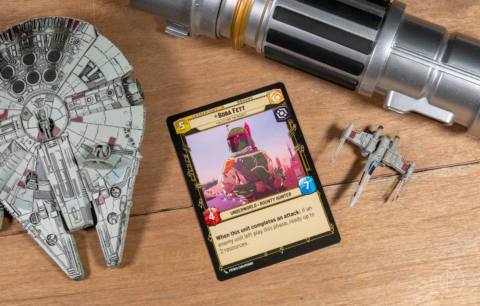 Boba Fett (Collecting the Bounty), a card from the Star Wars: Unlimited TCG, shown here on a table next to the Millennium Falcon.