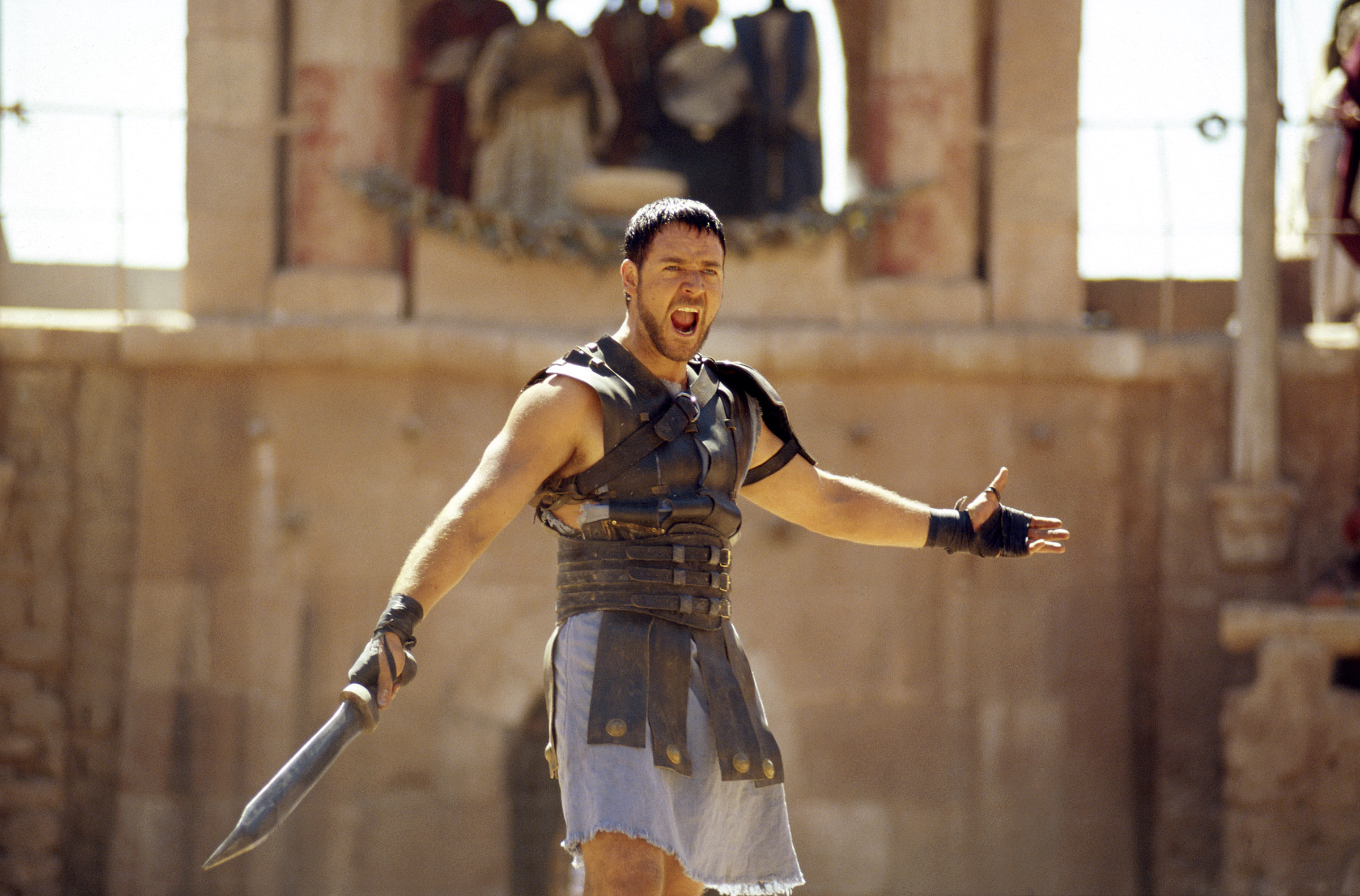 Maximus (Russell Crowe) yelling with his sword out during a fight in Gladiator 1