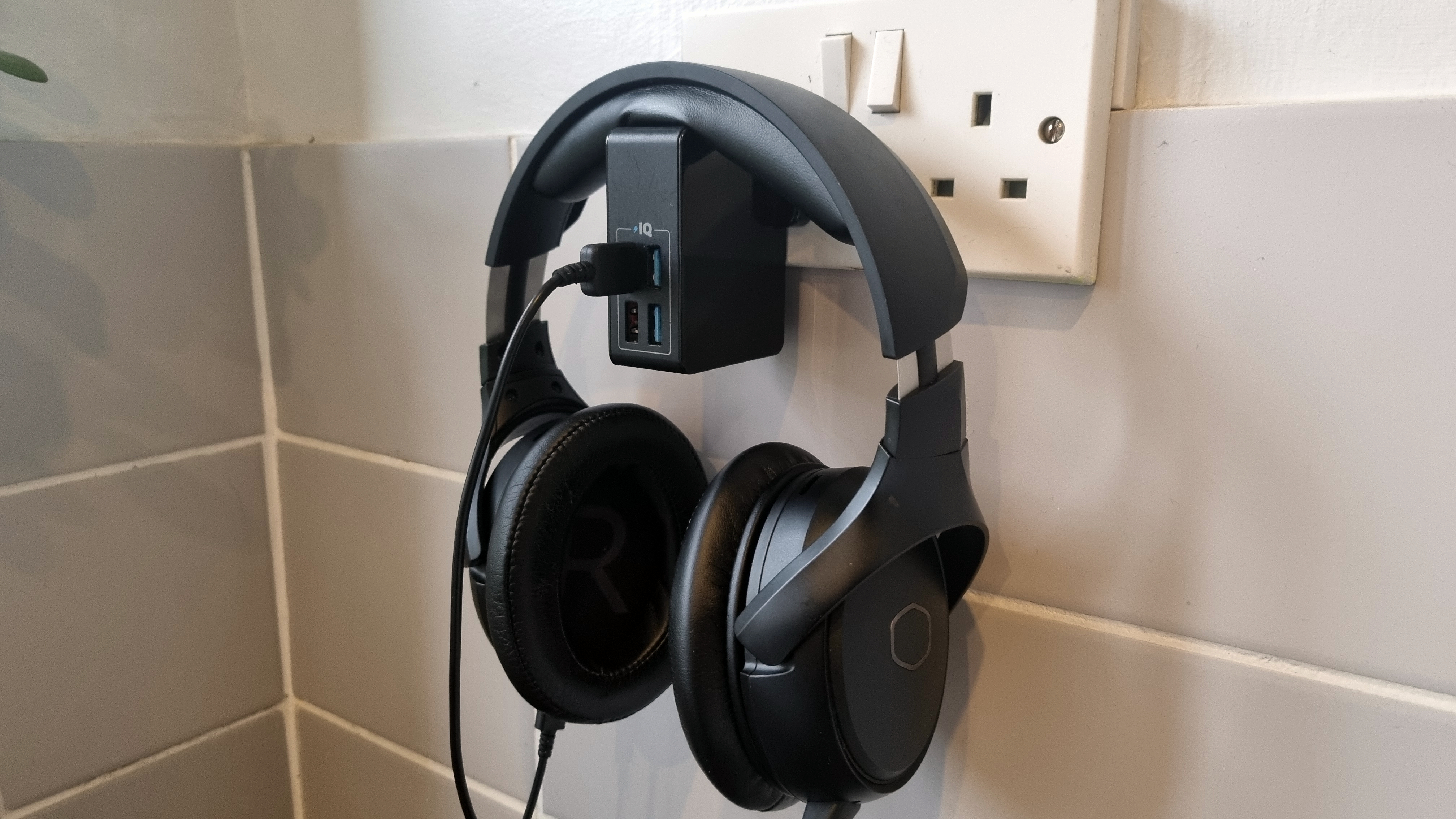 A headset charging from a UK wall plug.