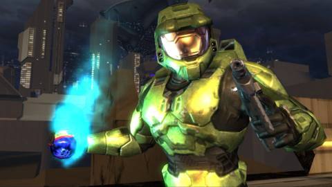 Master Chief holds a plasma grenade while standing in front of the New Mombasa skyline in the Halo 2 E3 demo