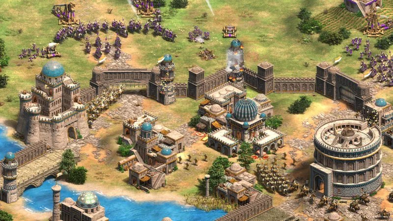 A screenshot from Age of Empires 2: Definitive Edition featuring an isometric view of a city with lots of buildings that have blue domes