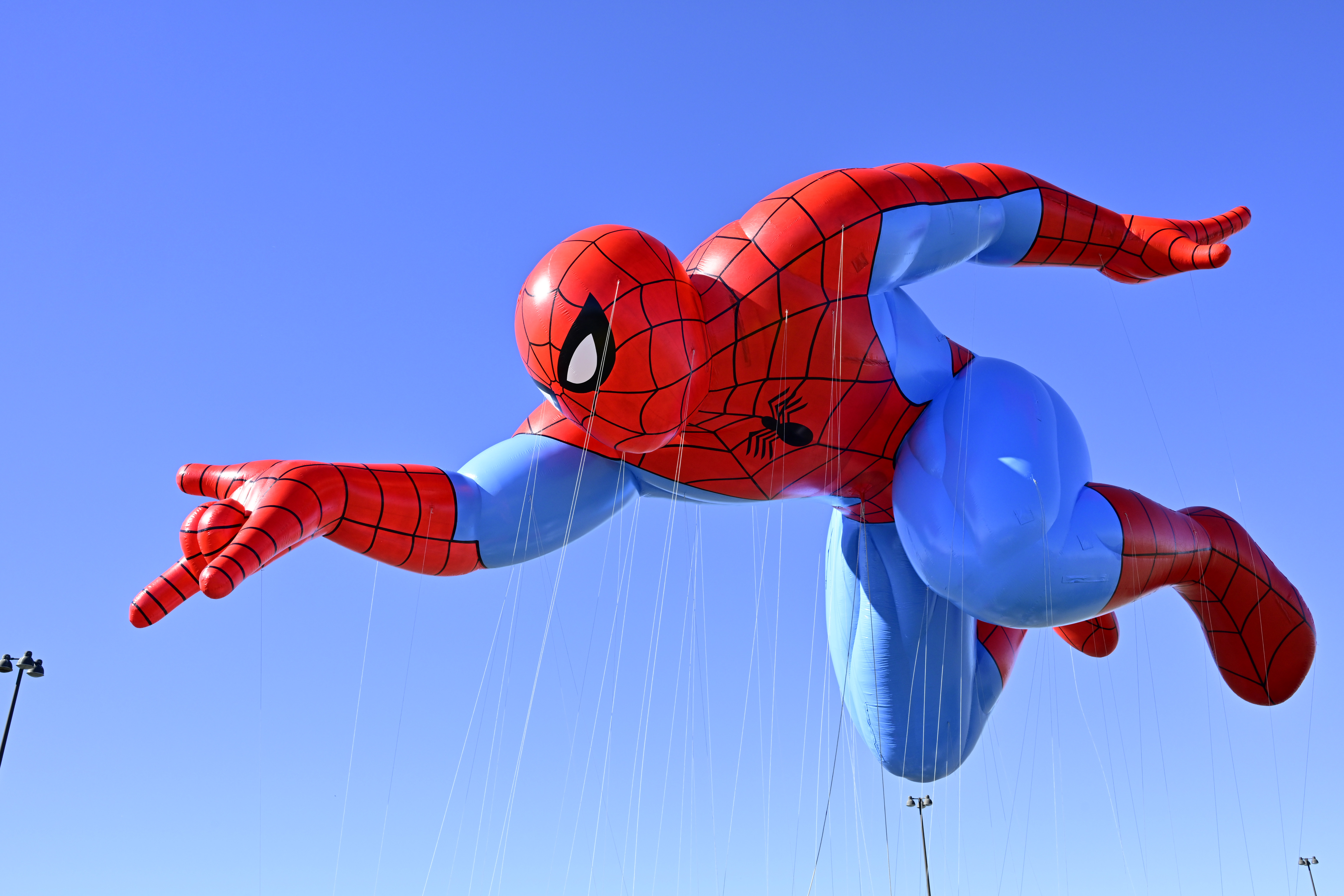 The Spider-Man parade balloon flies over Macy’s Balloonfest Preview. He’s depicted mid-webswing, with one hand extended, and has notably muscular thighs based on the art of John Romita Sr. 