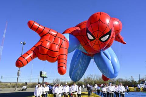 A new Spider-Man parade balloon flies at Macy's Balloonfest Preview at MetLife Stadium. The Spider-Man balloon is facing the camera, arm out-stretched to shoot a web, his surprisingly defined thigh muscles catching the sunlight.