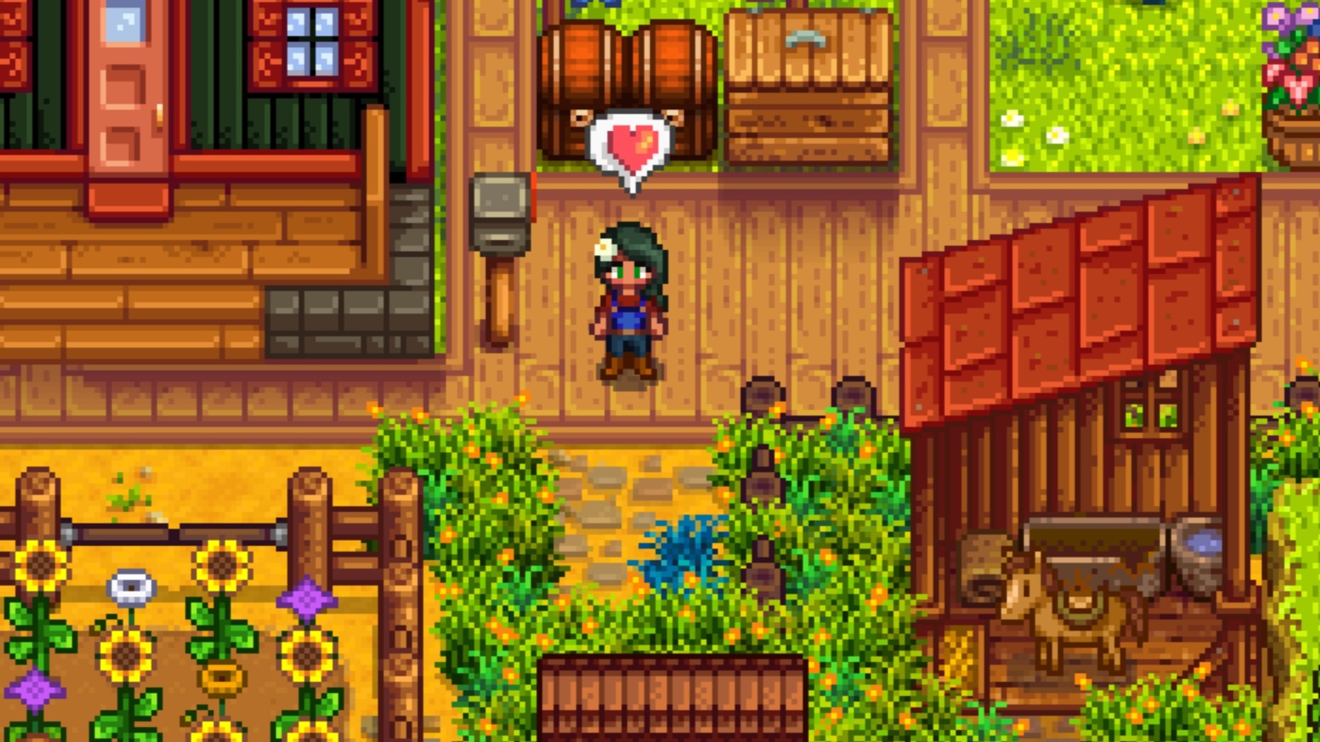 Stardew Valley farmer using the Heart emoji, standing in front of her house and surrounding by a horse, several chests, and wild flowers.