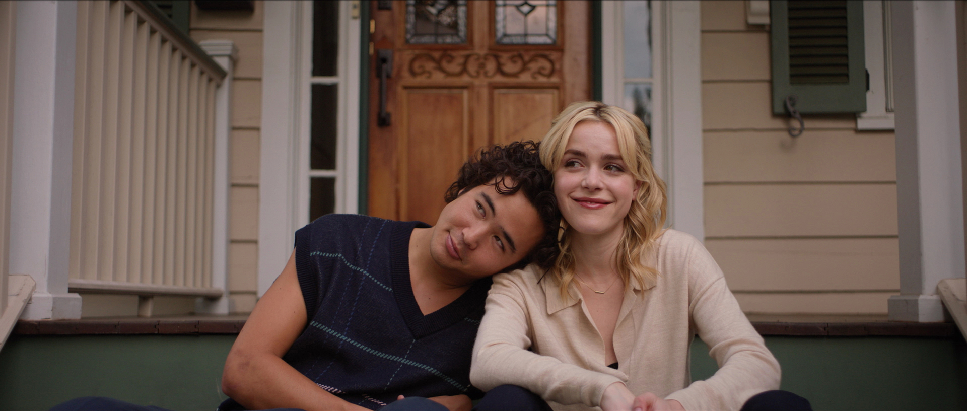 Miles Gutierrez-Riley and Kiernan Shipka sitting on a porch smiling in Sweethearts.