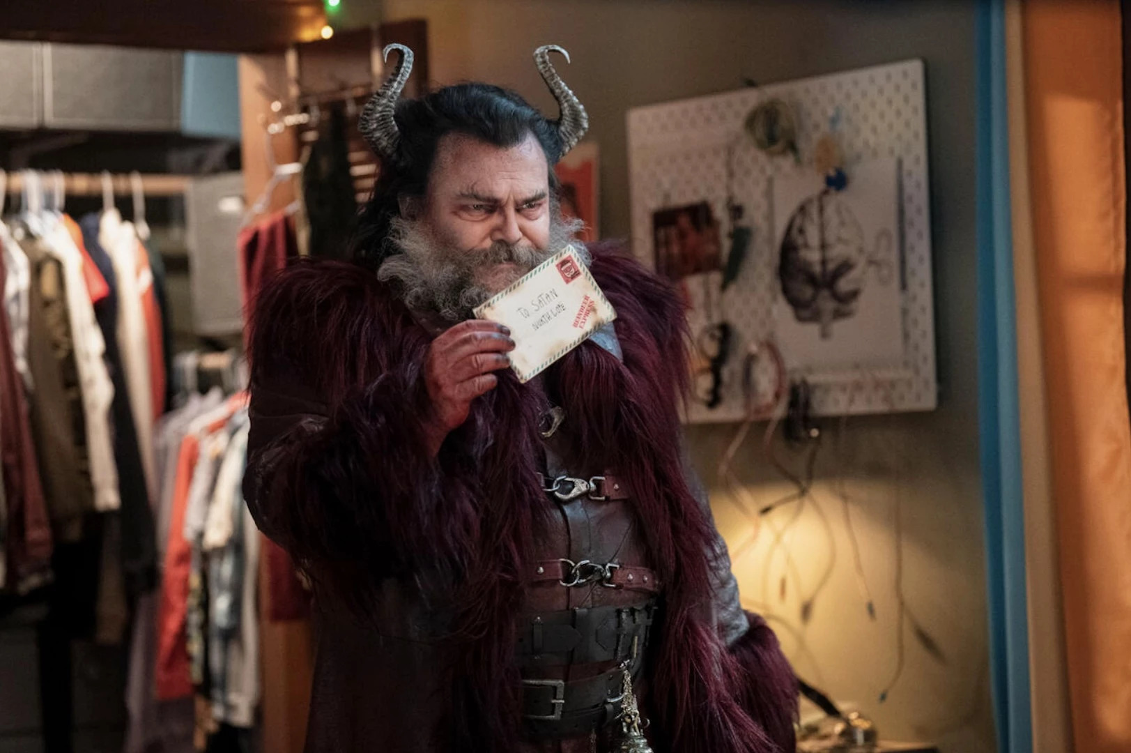 Jack Black dressed as Satan holding a letter addressed to him in Dear Santa.