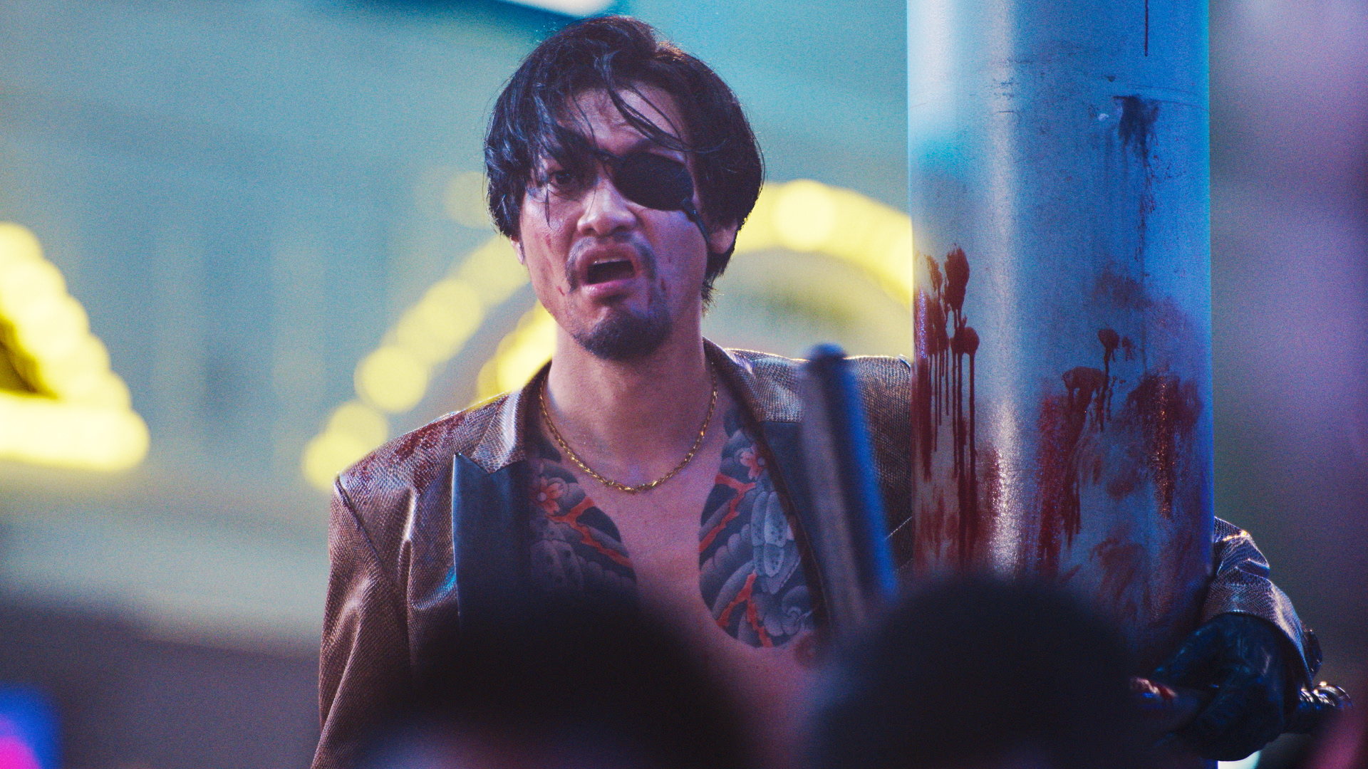 Majima (Munetaka Aoki) looking shocked with an eyepatch while hugging a bloody poll in Like a Dragon: Yakuza