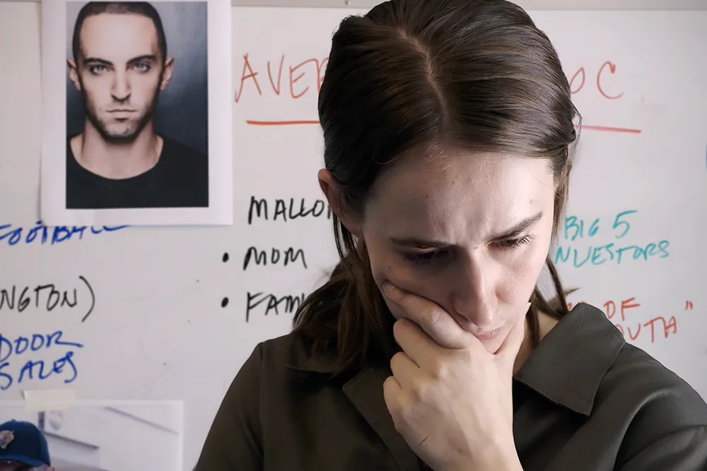 A woman posing in front of a dry erase board with a picture of a man tacked to top in Bad Actor: A Hollywood Ponzi Scheme. A woman posing in front of a dry erase board with a picture of a man tacked to top in Bad Actor: A Hollywood Ponzi Scheme.