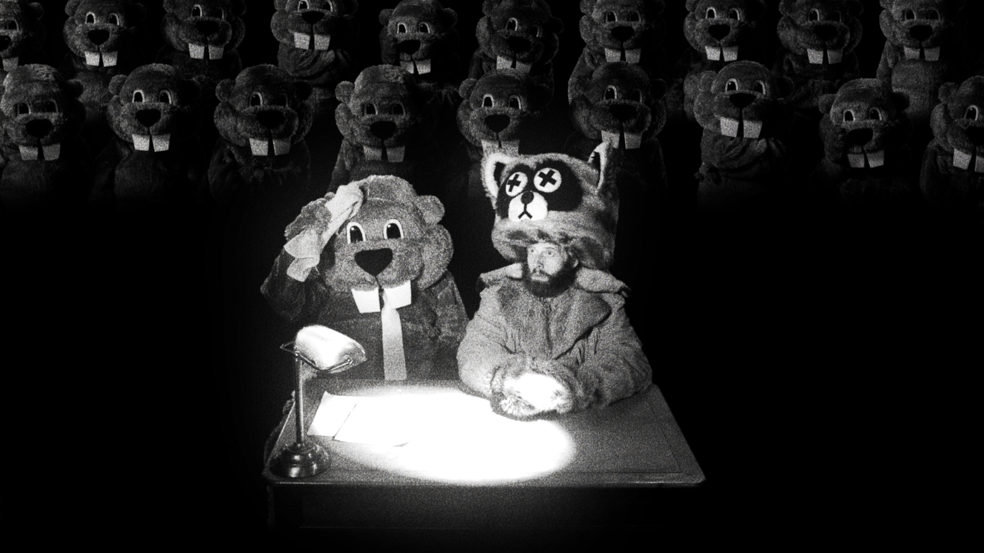 The protagonist of Hundreds of Beavers sits on trial, as his beaver attorney (a man in a beaver suit) wipes his brow. Dozens of beavers sit behind them in the gallery.