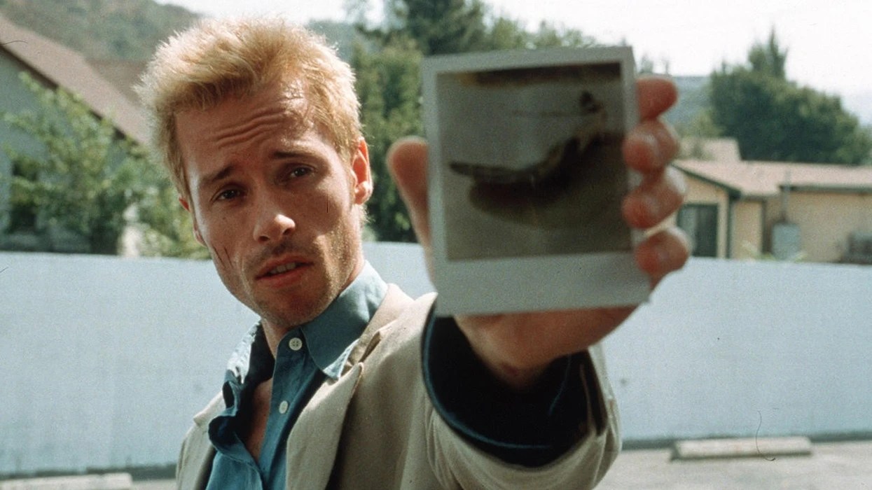 Guy Pearce holding a polaroid photo in his hand in Memento.