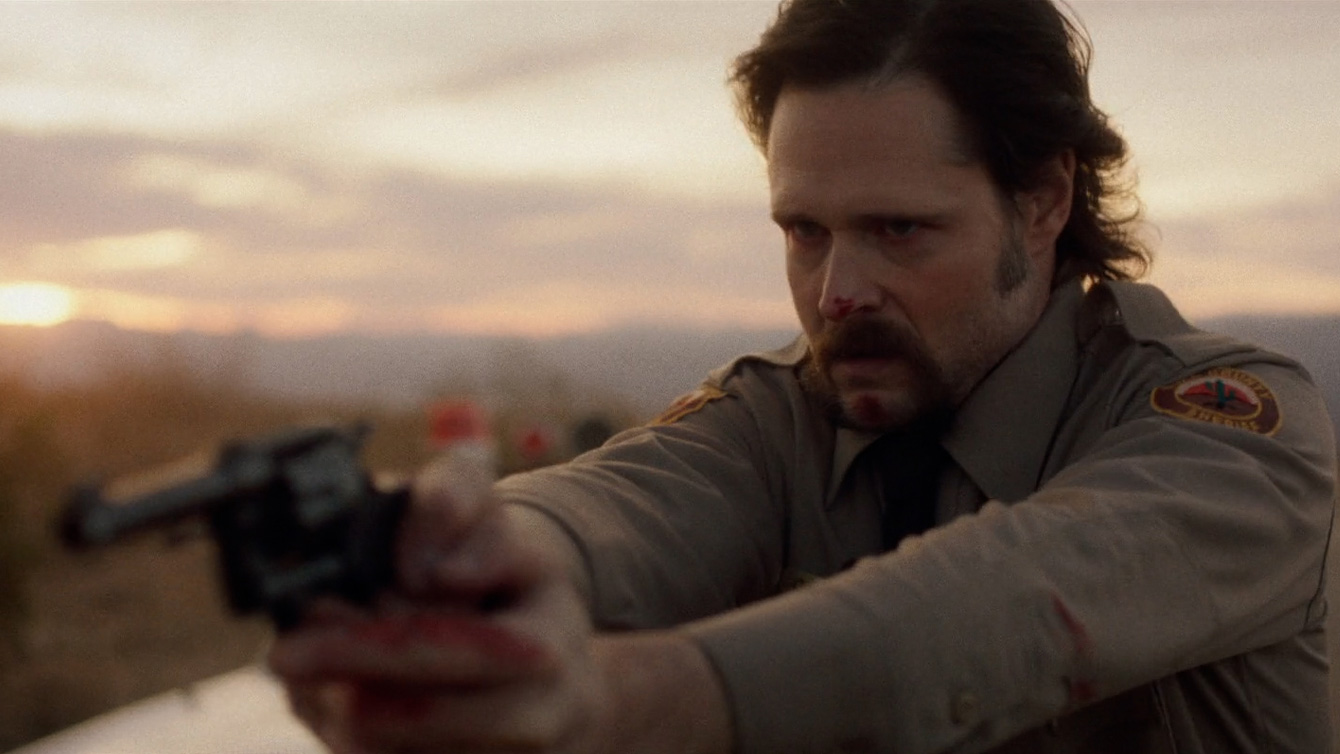 Michael Abbott Jr. holding a gun and wearing a police officer uniform in The Last Stop in Yuma County Michael Abbott Jr. holding a gun and wearing a police officer uniform in The Last Stop in Yuma County