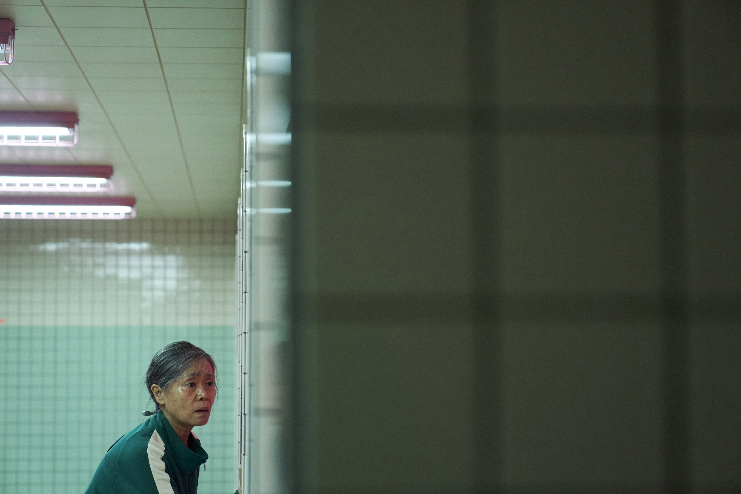 Geum-ja (Kang Ae-sim) looking concerned in a bathroom in a still from Squid Game season 2