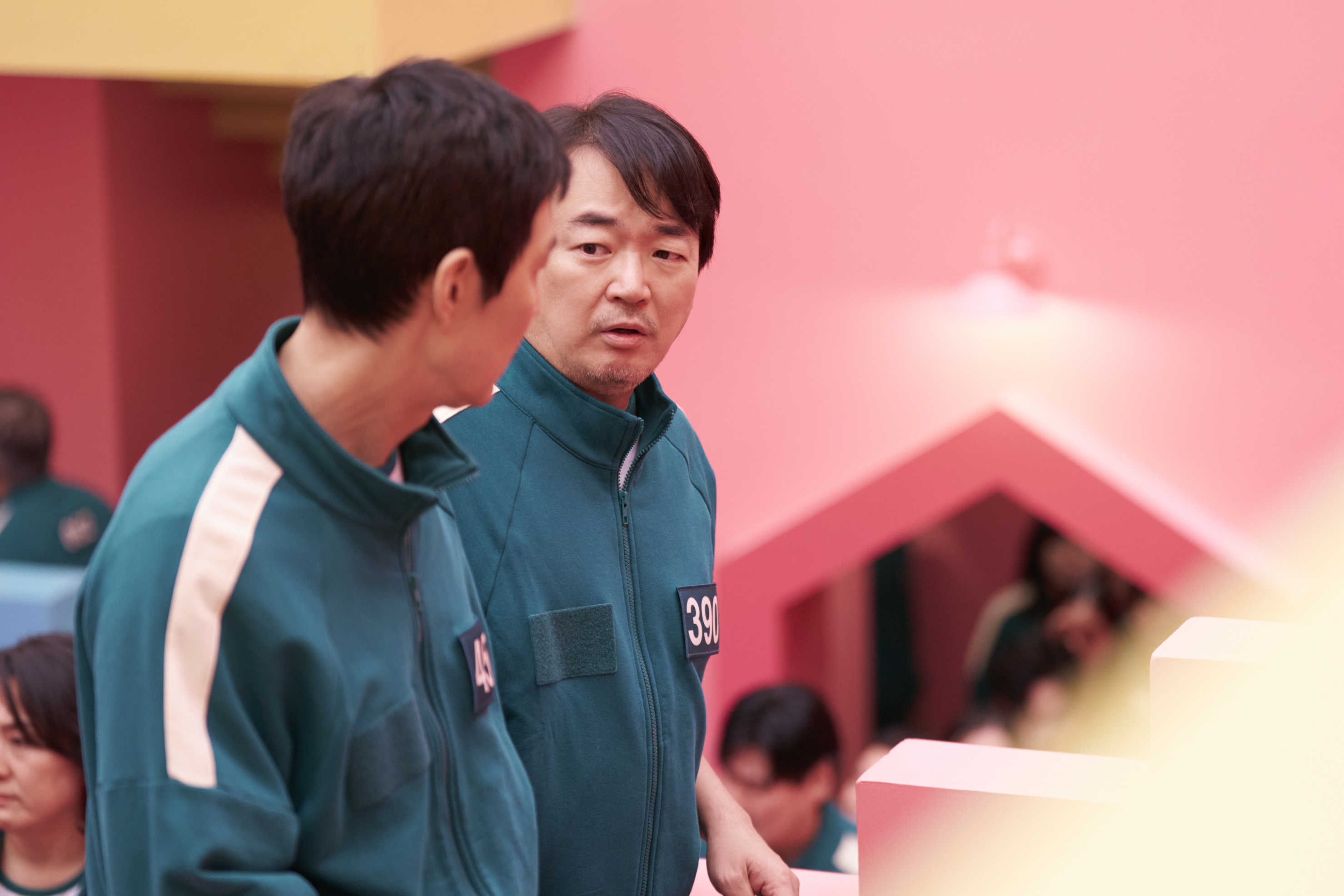 Jung-bae (Lee Seo-hwan) talking to Gi-hun in a still from Squid Game season 2