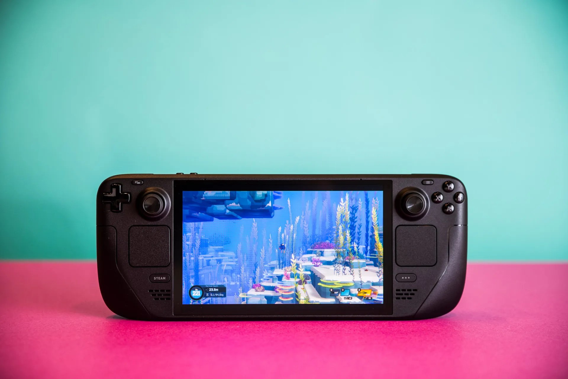 A photo of the standard Steam Deck OLED on a blue and pink background