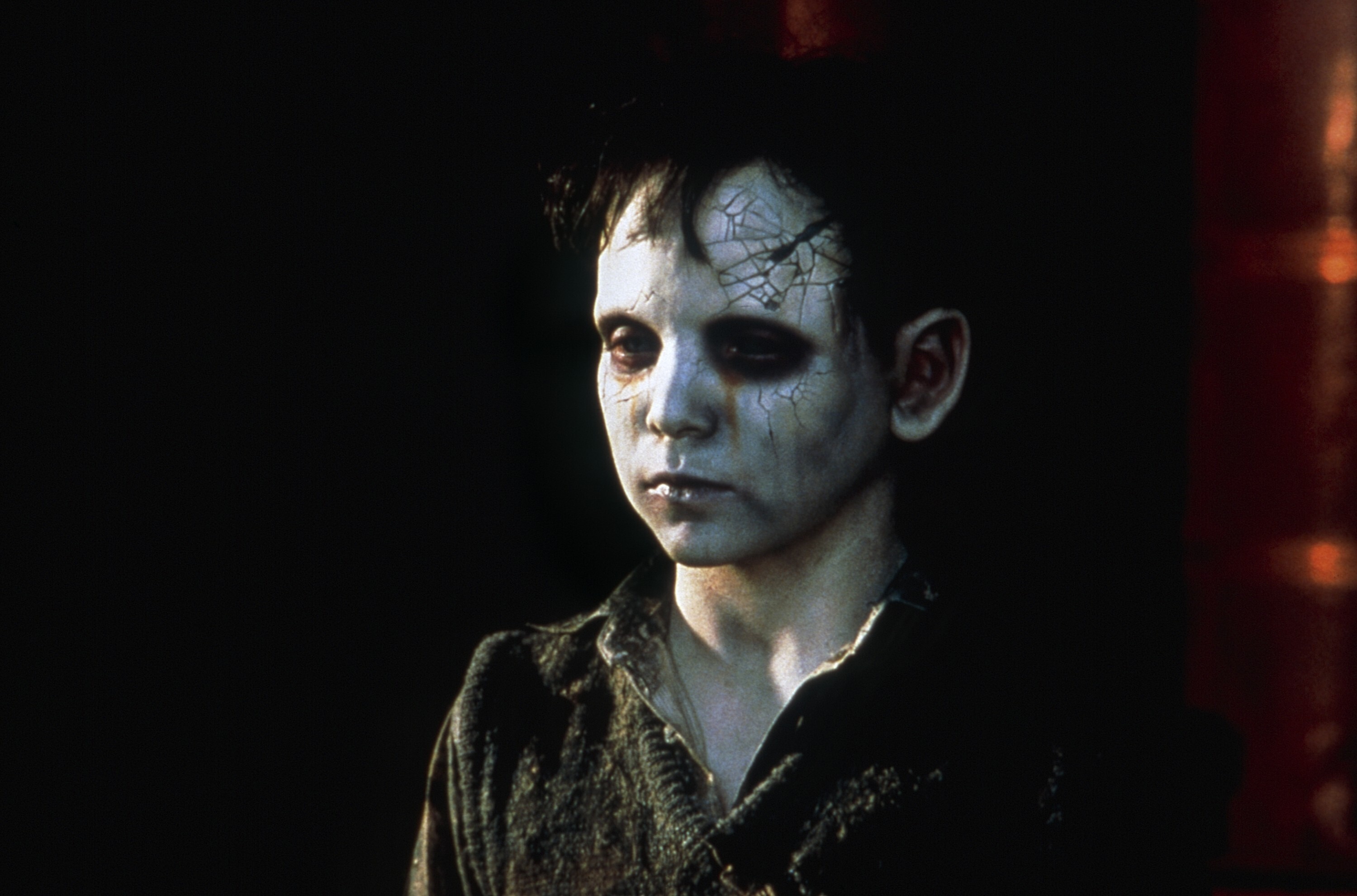 A boy with a pale face and crack in his head stands with a still face in The Devil’s Backbone A boy with a pale face and crack in his head stands with a still face in The Devil’s Backbone