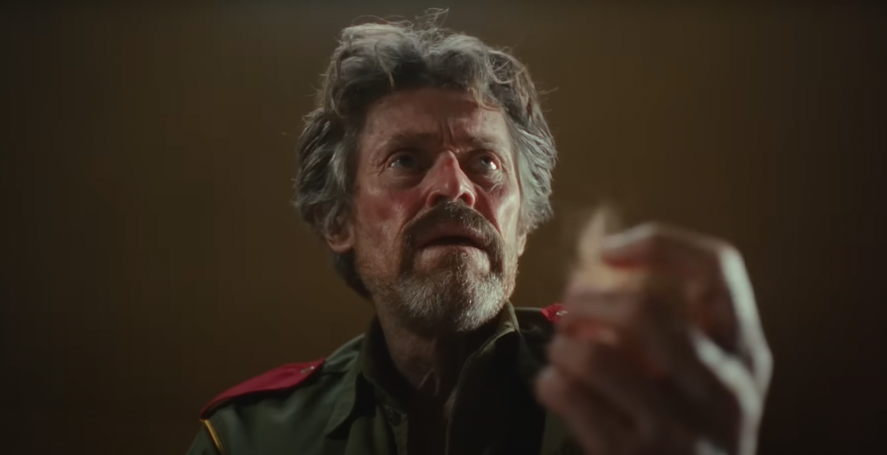 Willem Dafoe holding a piece of bloody fur in The Legend of Ochi Willem Dafoe holding a piece of bloody fur in The Legend of Ochi