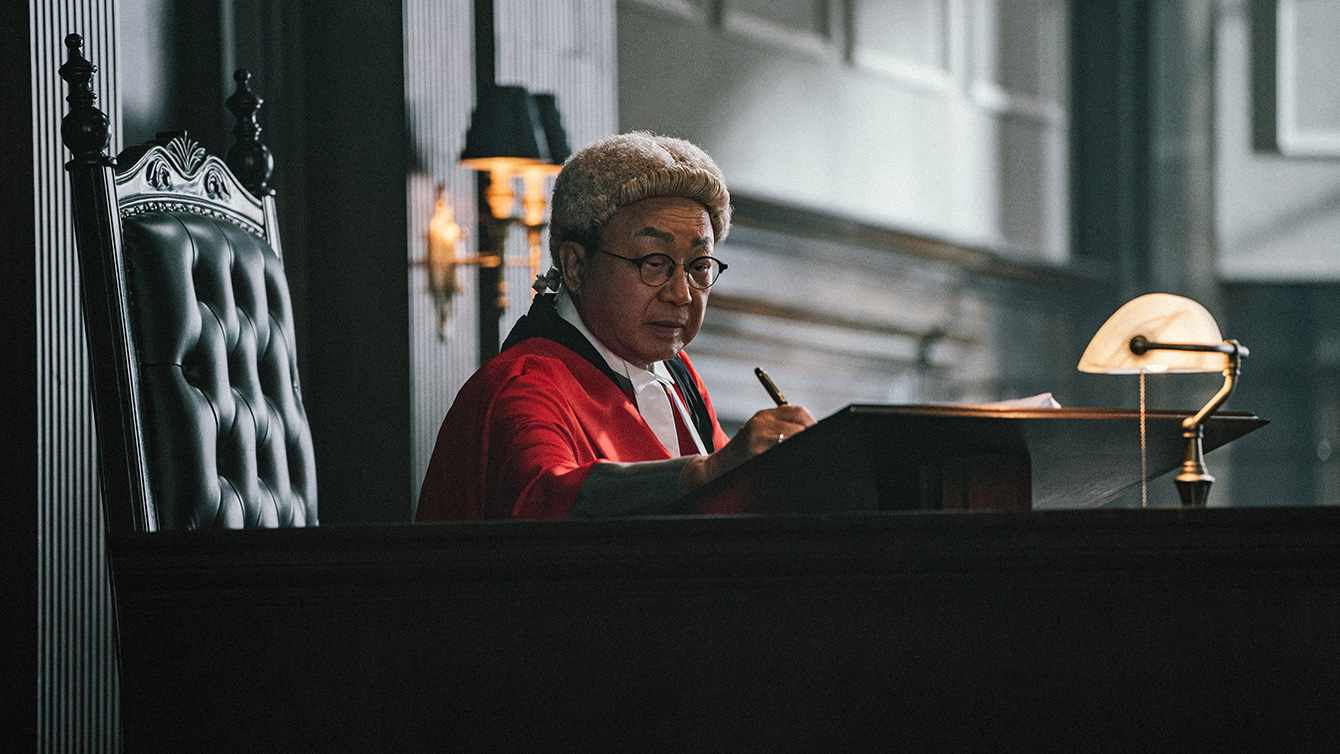 A Hong Kong judge, complete with bright red robes and a white wig, in The Prosecutor. A Hong Kong judge, complete with bright red robes and a white wig, in The Prosecutor.