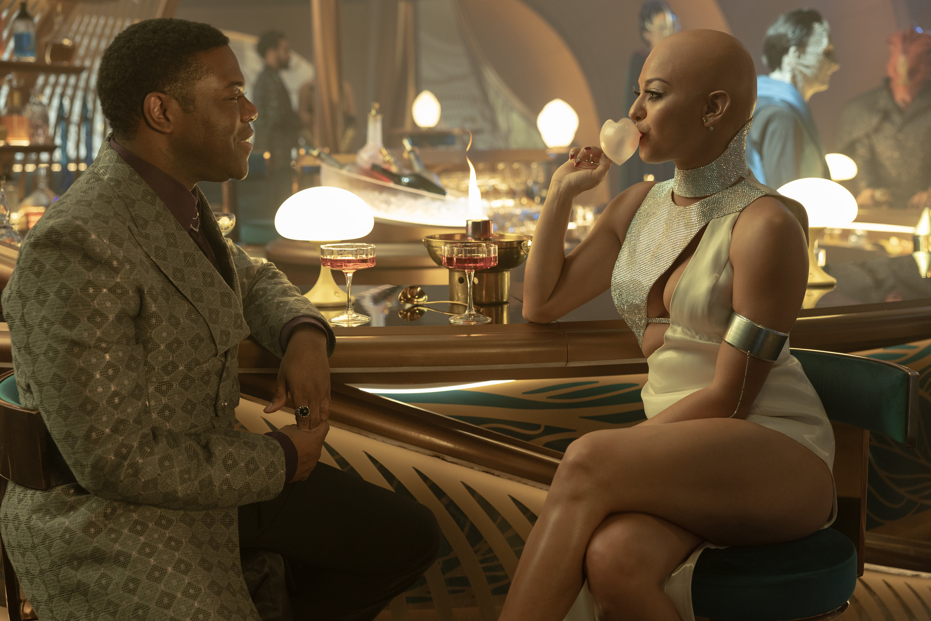 Sam Richardson as Quasi and Humberly Gonzalez as Melle sit at a fancy bar in Star Trek: Section 31. Melle is blowing a bubblegum bubble that’s somehow shaped like a perfect pink heart.