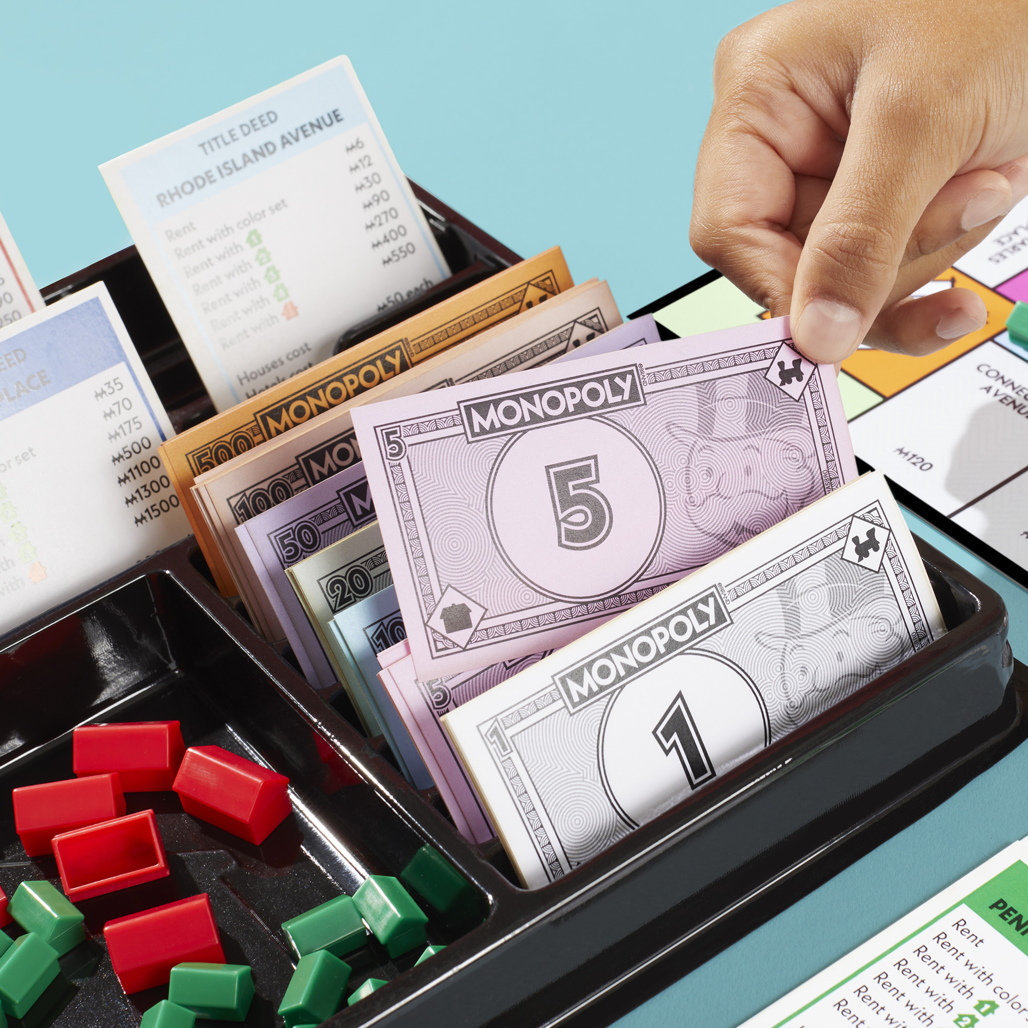 The new Monopoly storage tray holds the money, the deeds, and all the houses and hotels within easy reach.