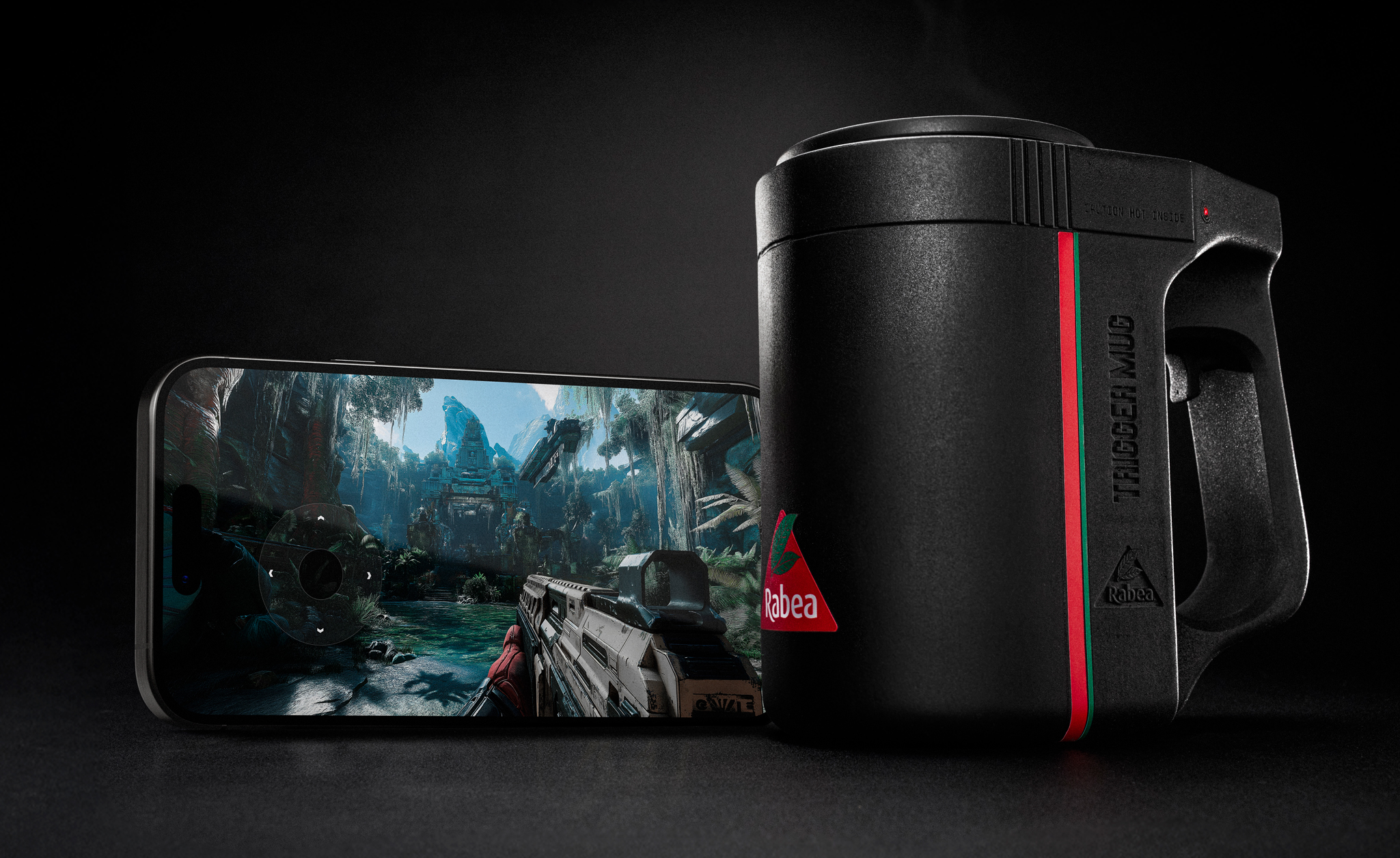 A mug with a trigger next to a phone displaying a shooter game