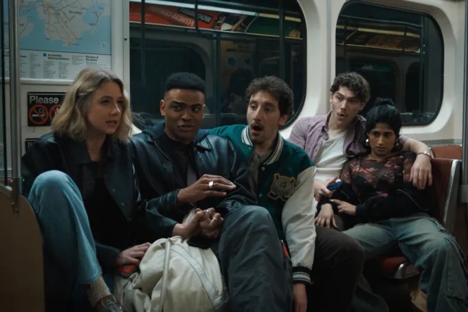 Several young adults sit on a subway car in Adults 