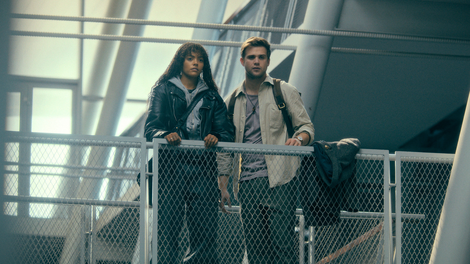 Quintessa Swindell and Leo Woodall stand next to each other looking over a railing in Prime Target 