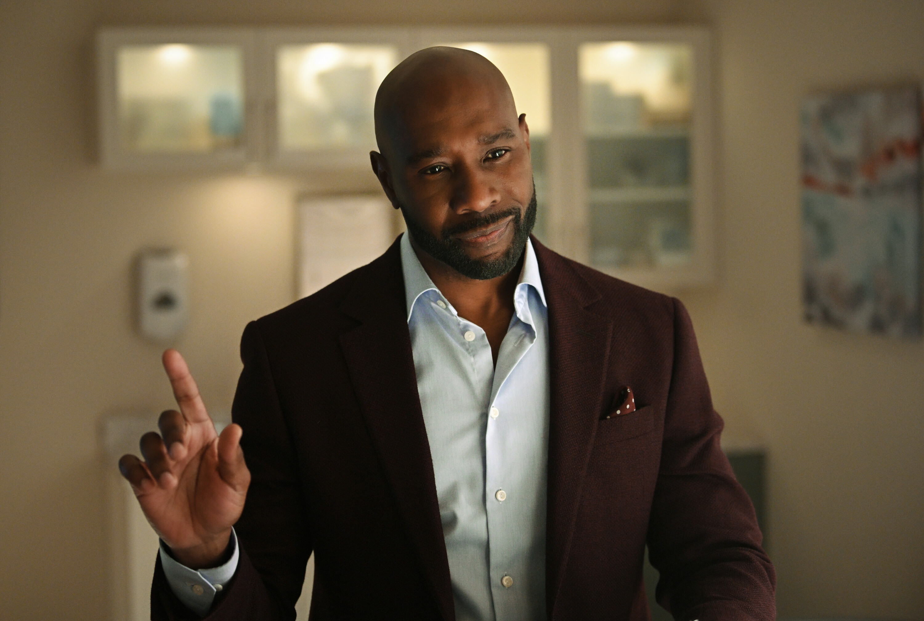 Morris Chestnut as Watson in Watson holding a finger up and wearing a sports coat