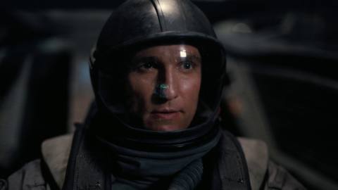 Matthew McConaughey wearing a helmet with the reflection of a control visible on his visor in Interstellar.