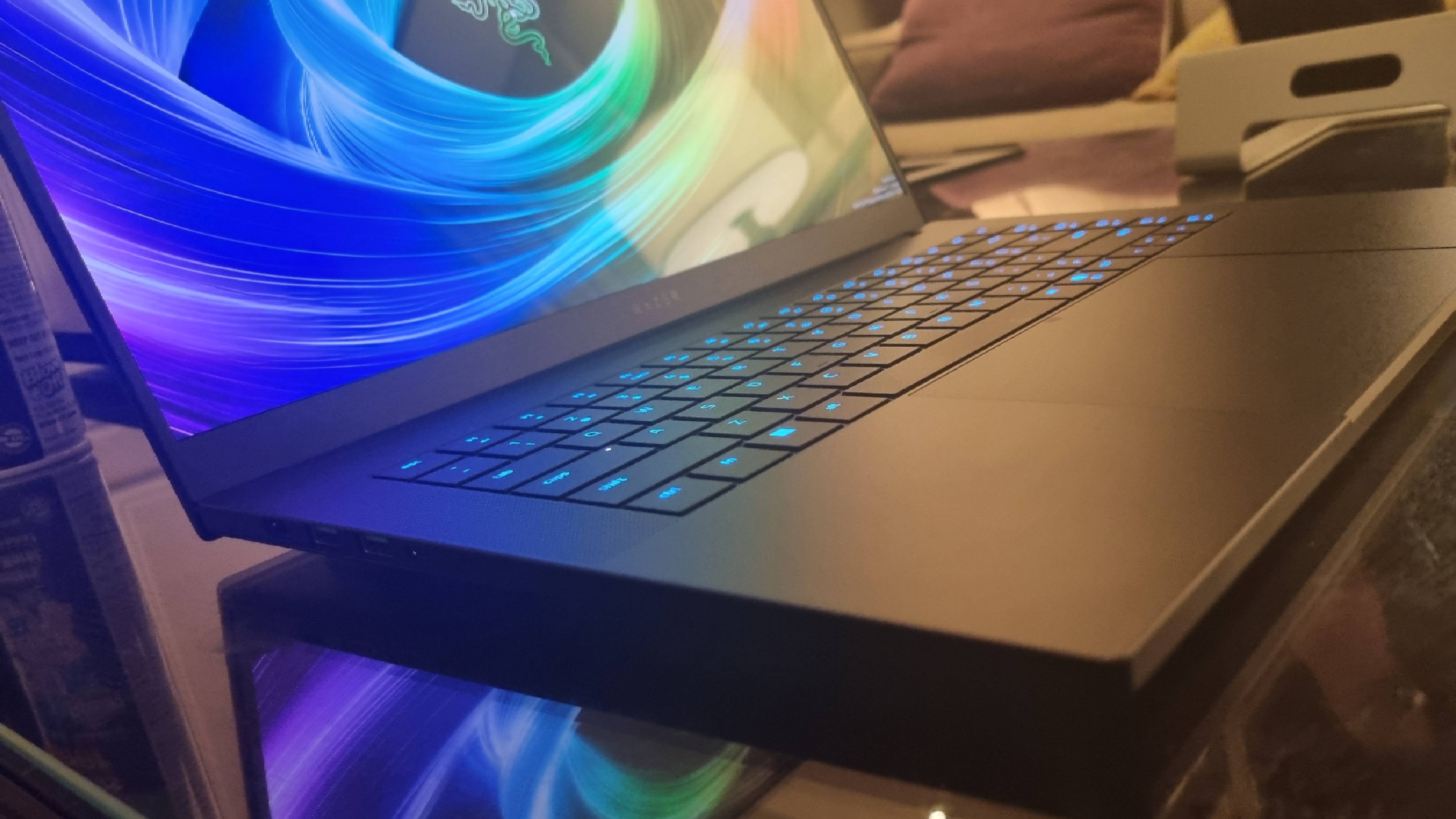 The Razer Blade 16 shot at an angle, showing the keyboard lit up in blue.