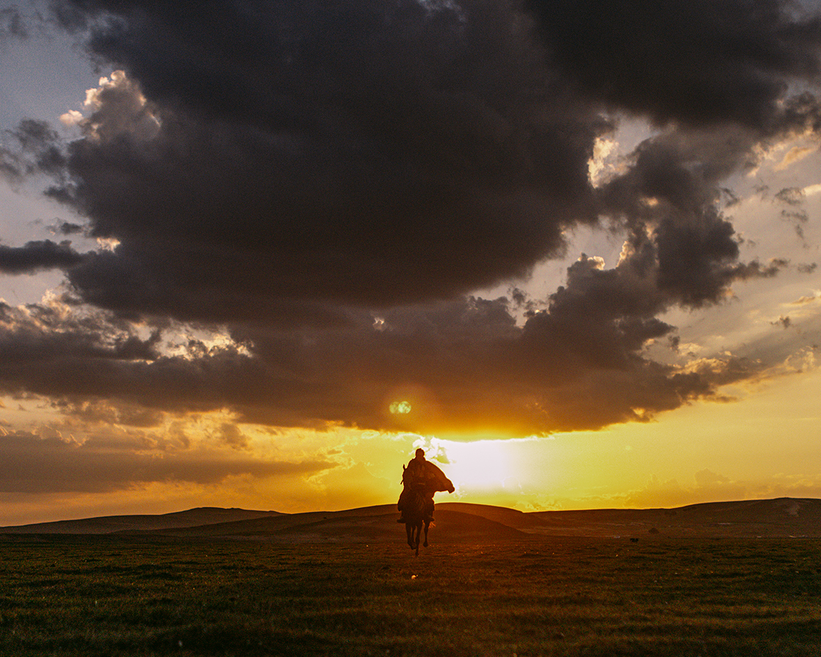 A rider on horseback comes toward the camera in Legends of the Condor Heroes: The Gallants as the sun sets behind them