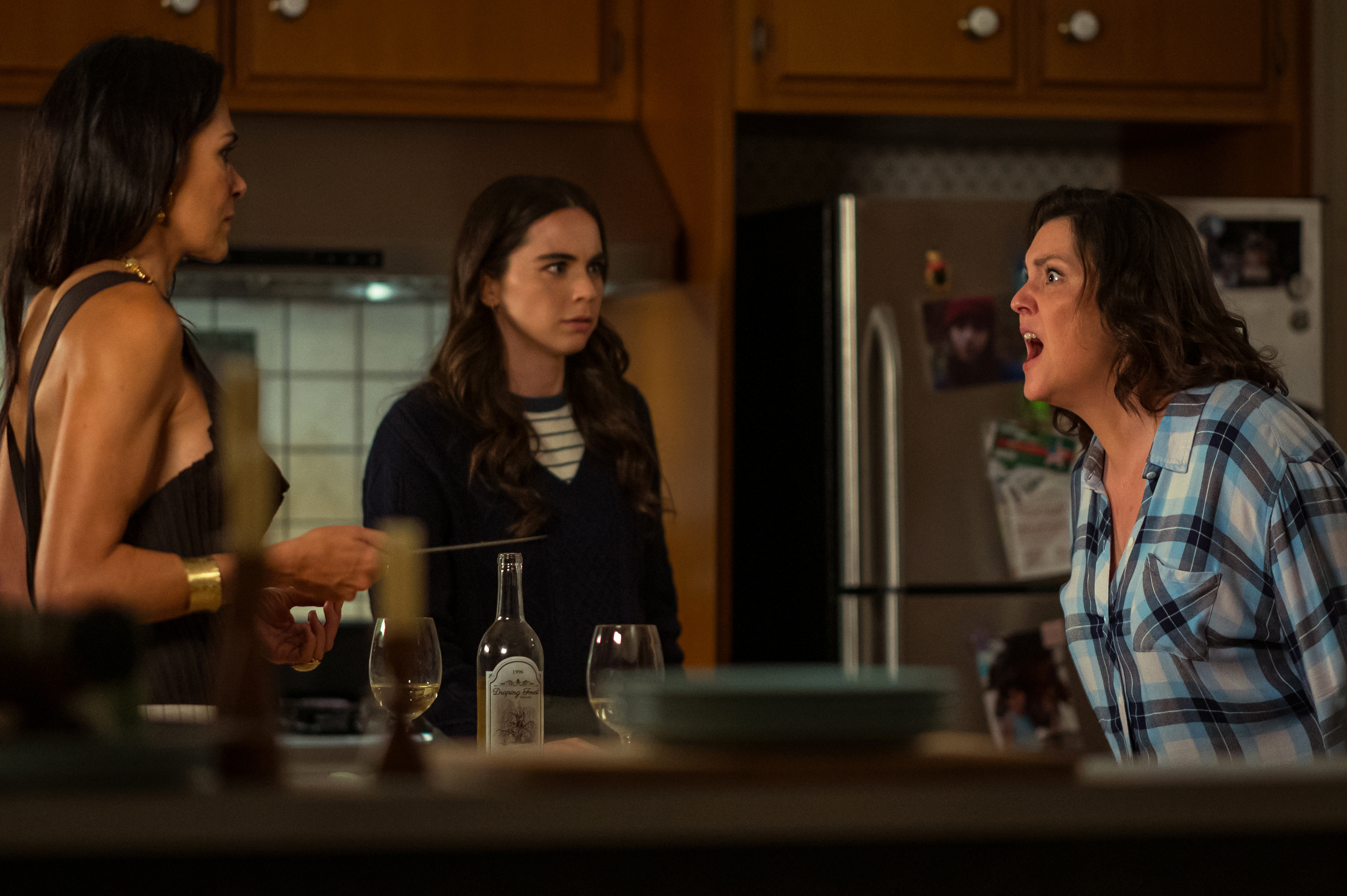 Shauna screaming at Lottie in her kitchen with Callie in the background in a still from Yellowjackets season 3 Shauna screaming at Lottie in her kitchen with Callie in the background in a still from Yellowjackets season 3