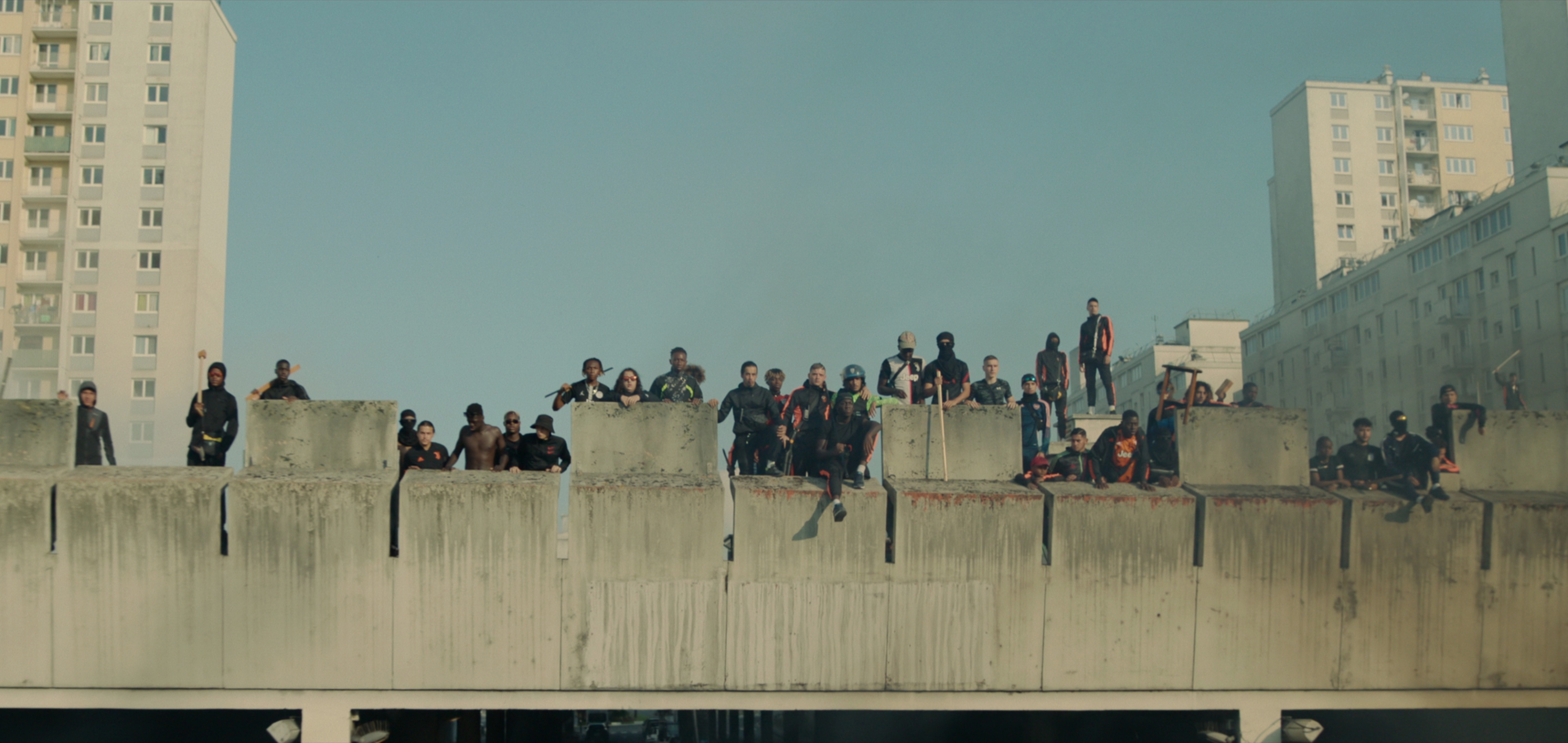 A large group of protestors stand atop a building looking down in Athena A large group of protestors stand atop a building looking down in Athena