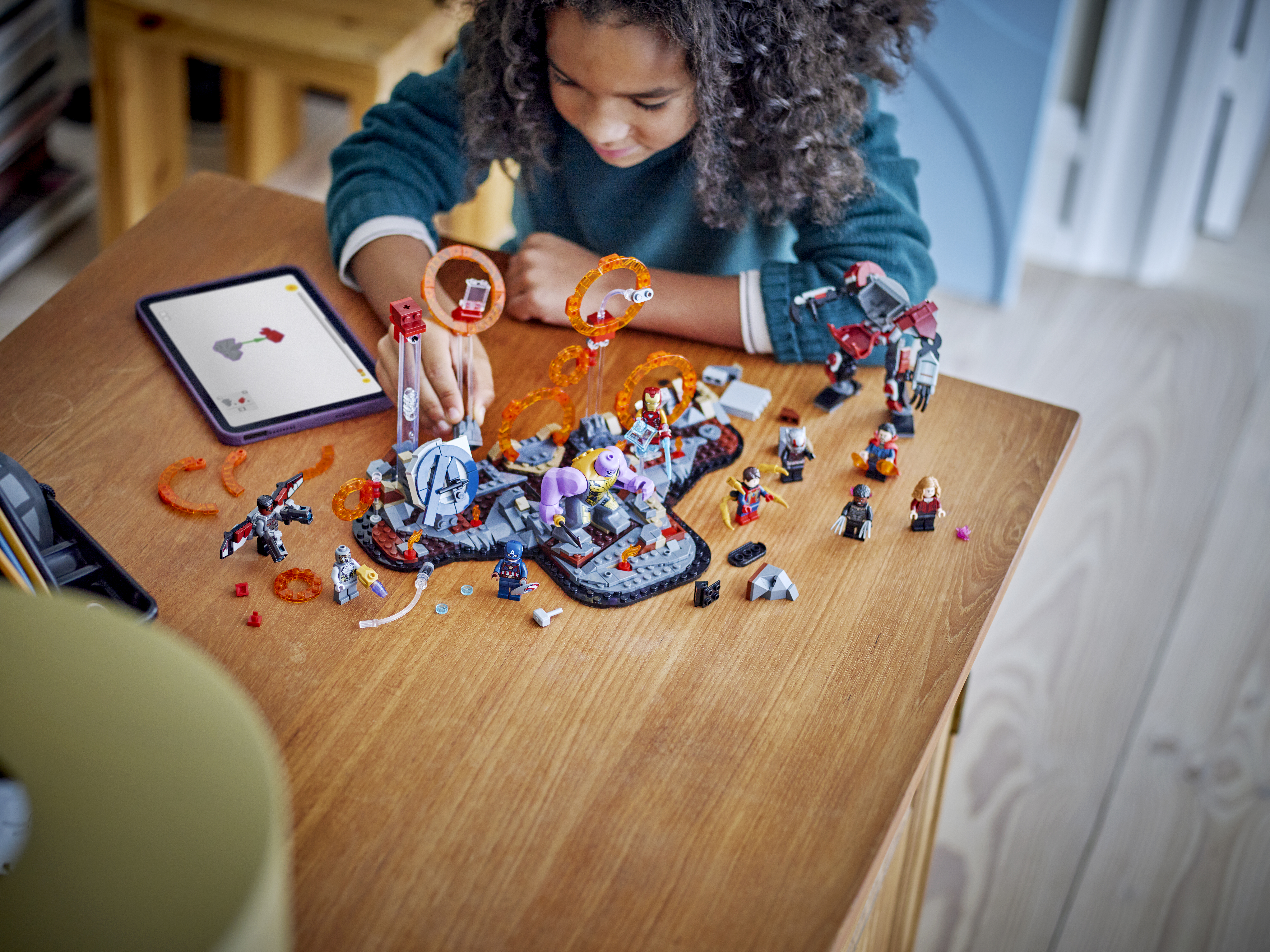 A lifestyle photo of a child assembling the Avengers: Endgame Final Battle Lego set on a table A lifestyle photo of a child assembling the Avengers: Endgame Final Battle Lego set on a table