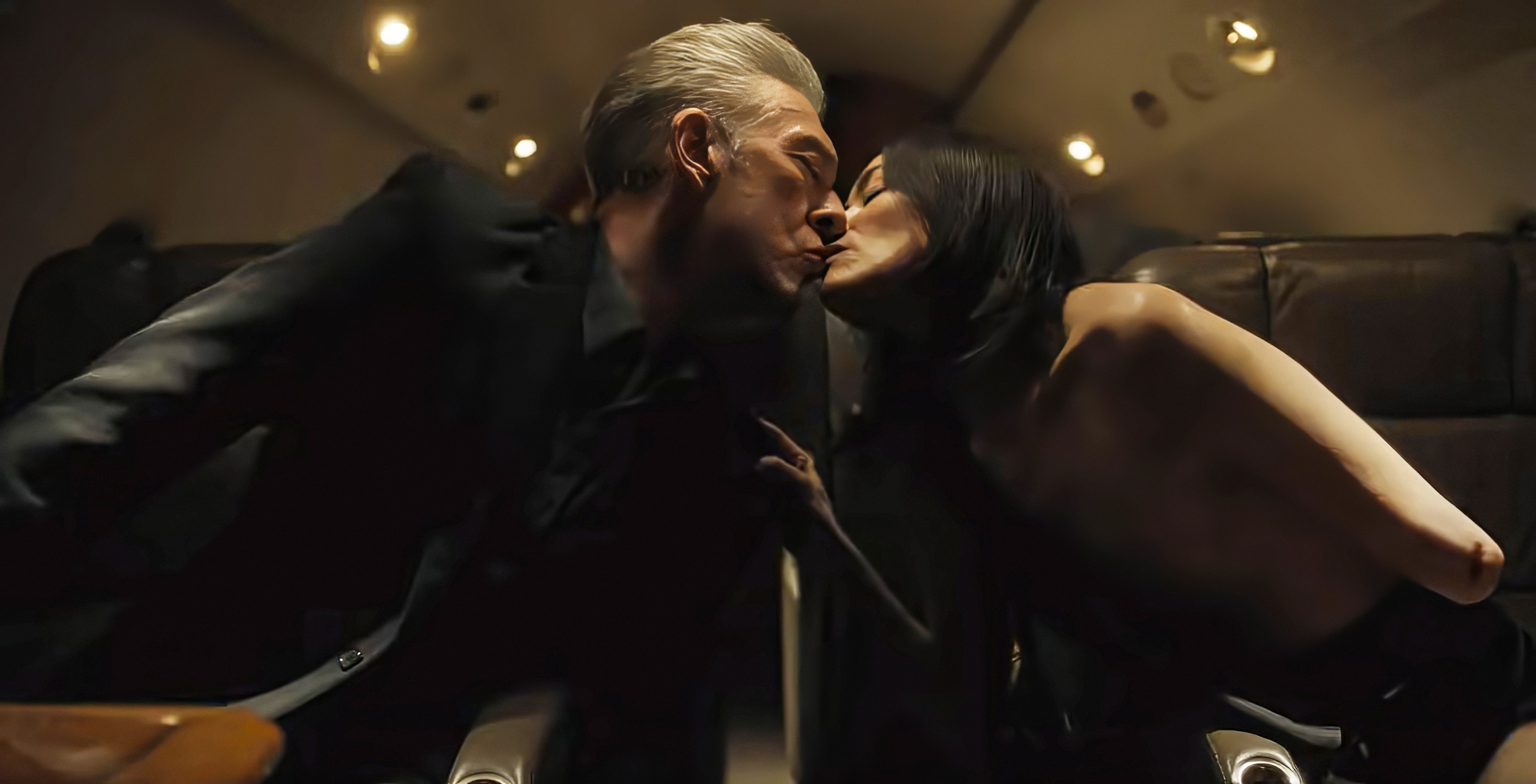 Karsh (Vincent Cassel) kissing Soo-Min (Sandrine Holt) on a plane, with her missing her left breast and the lower half of her left arm