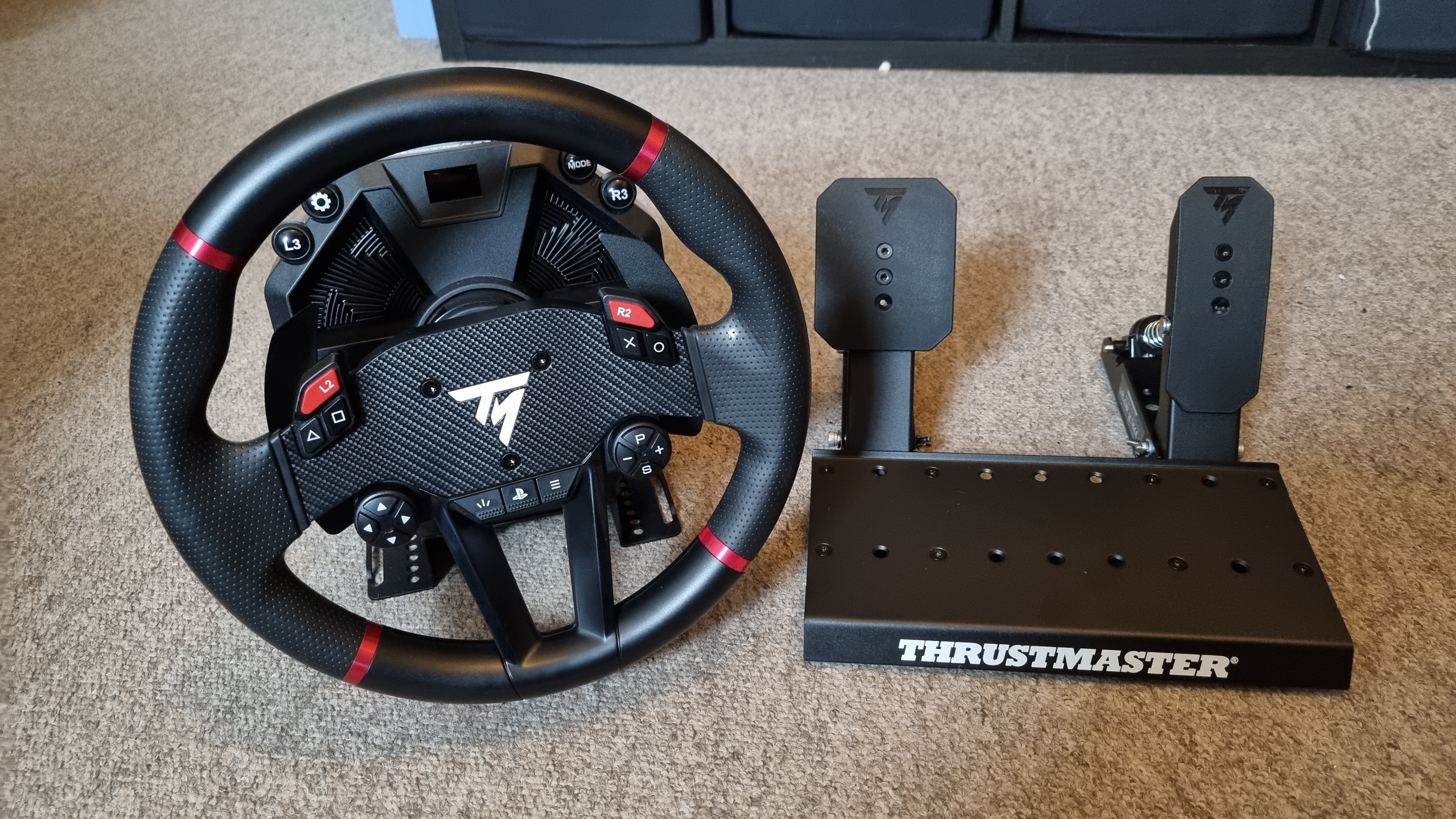 The Thrustmaster T598 wheel and pedal set, show from various angles on carpet