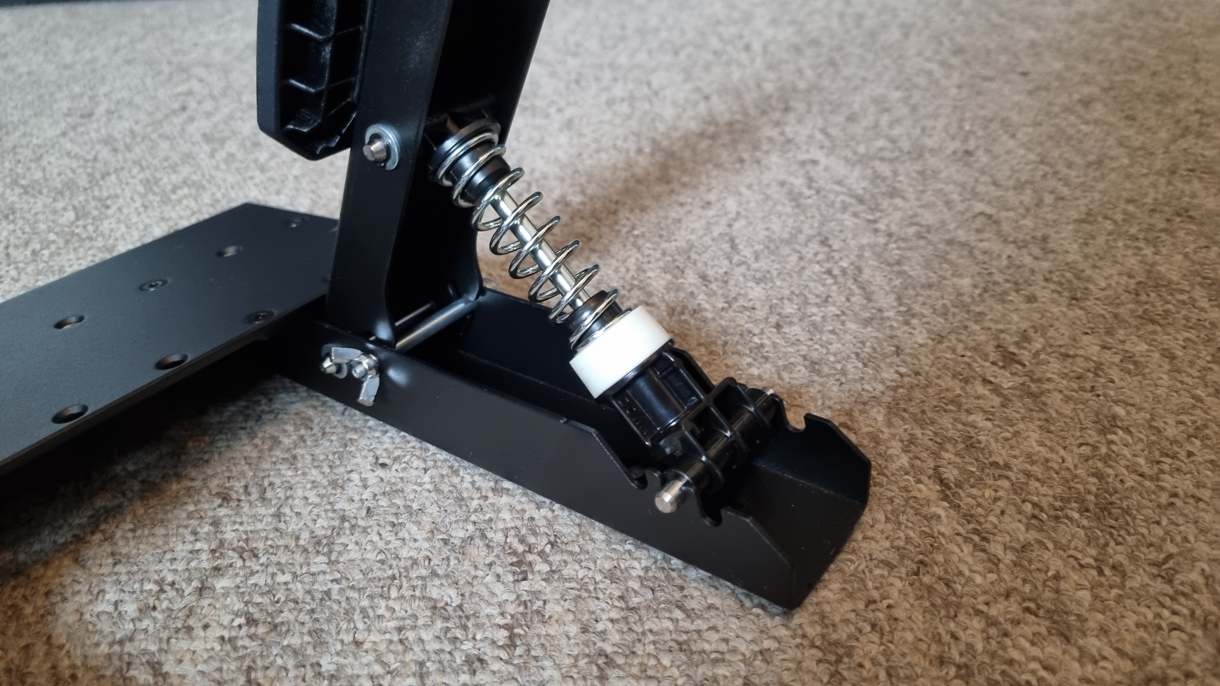 The Thrustmaster T598 pedals on carpet, showing the rear brake pedal mechanism